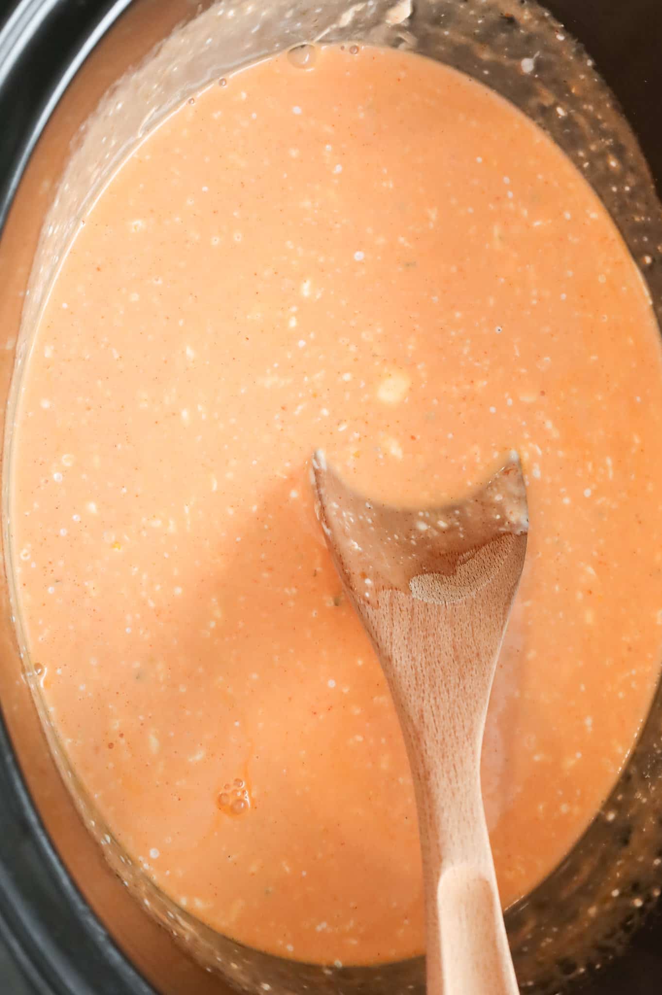 Buffalo chicken sauce mixture cooking in a slow cooker