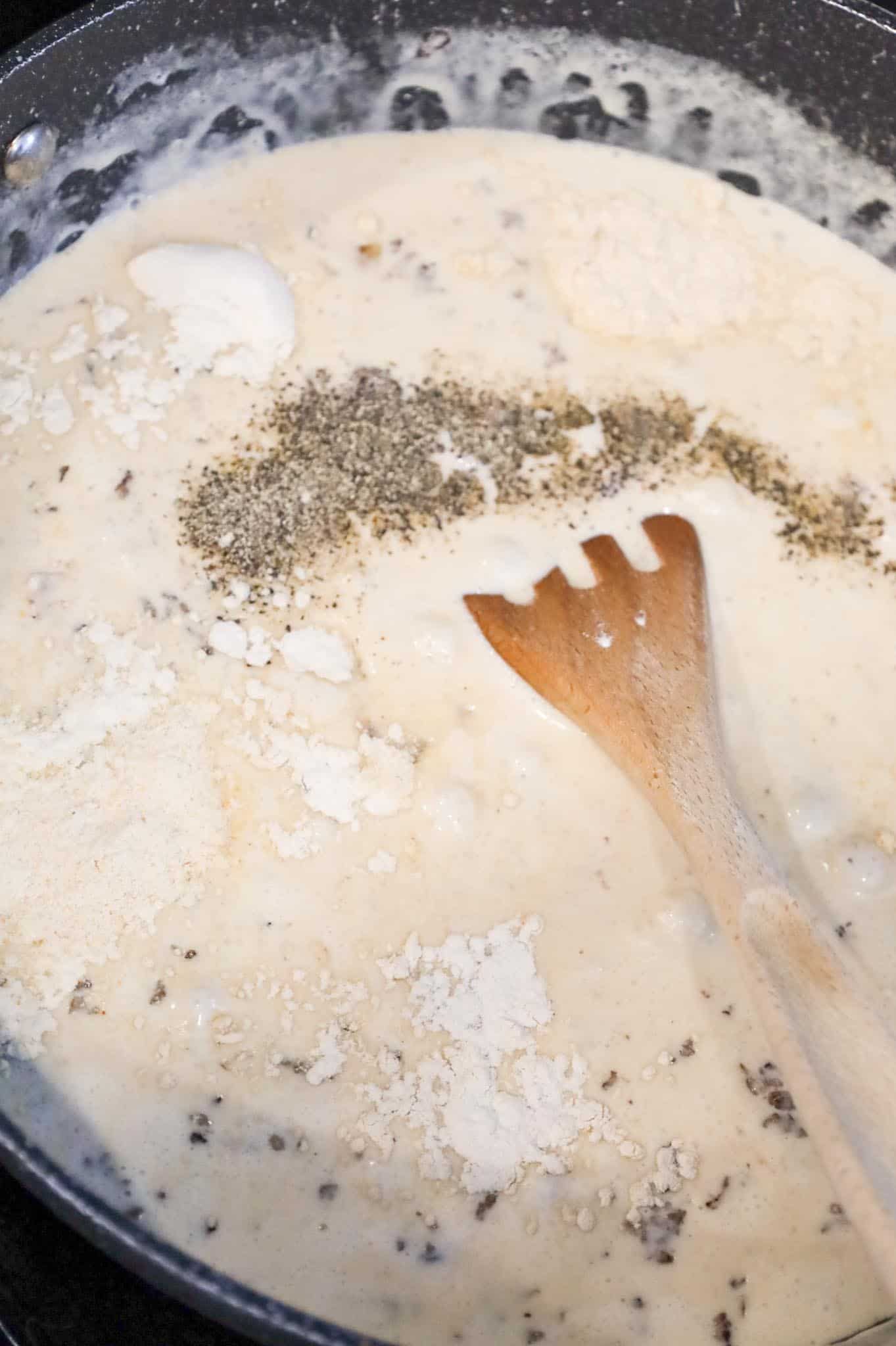 spices added to skillet with heavy cream and cheddar soup mixture