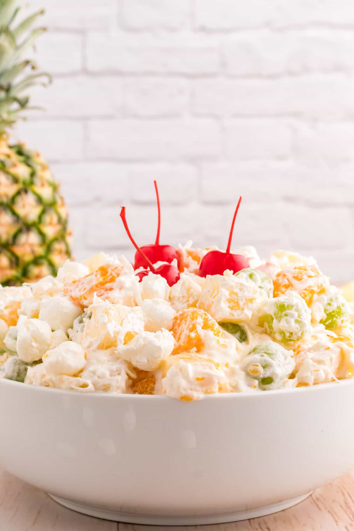 Hawaiian Ambrosia Salad is a sweet and creamy fruit salad recipe loaded with pineapple, mandarins, grapes, shredded coconut, mini marshmallows and Cool Whip.