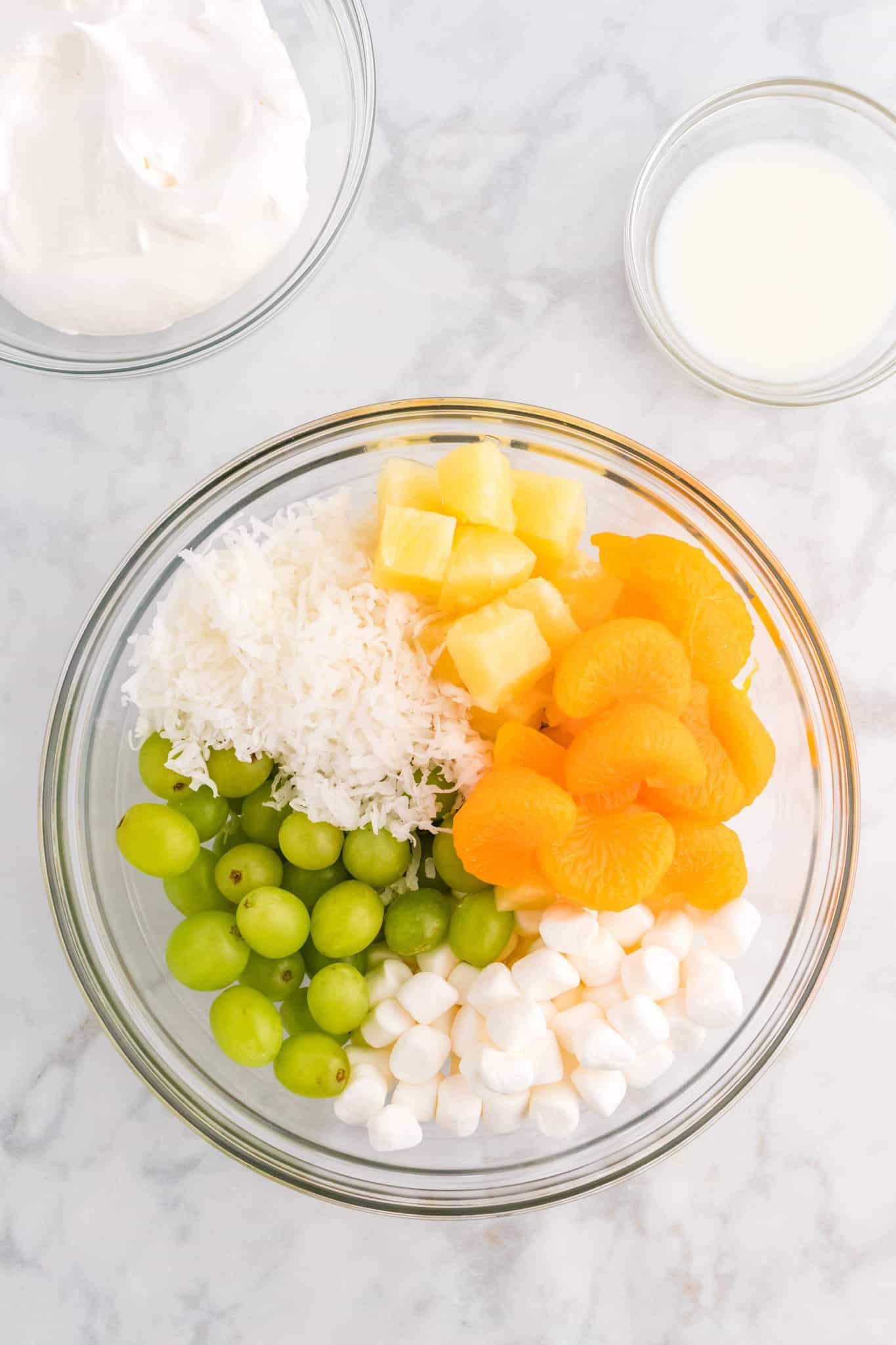 green grapes, shredded coconut, mandarin slices and mini marshmallows in a bowl