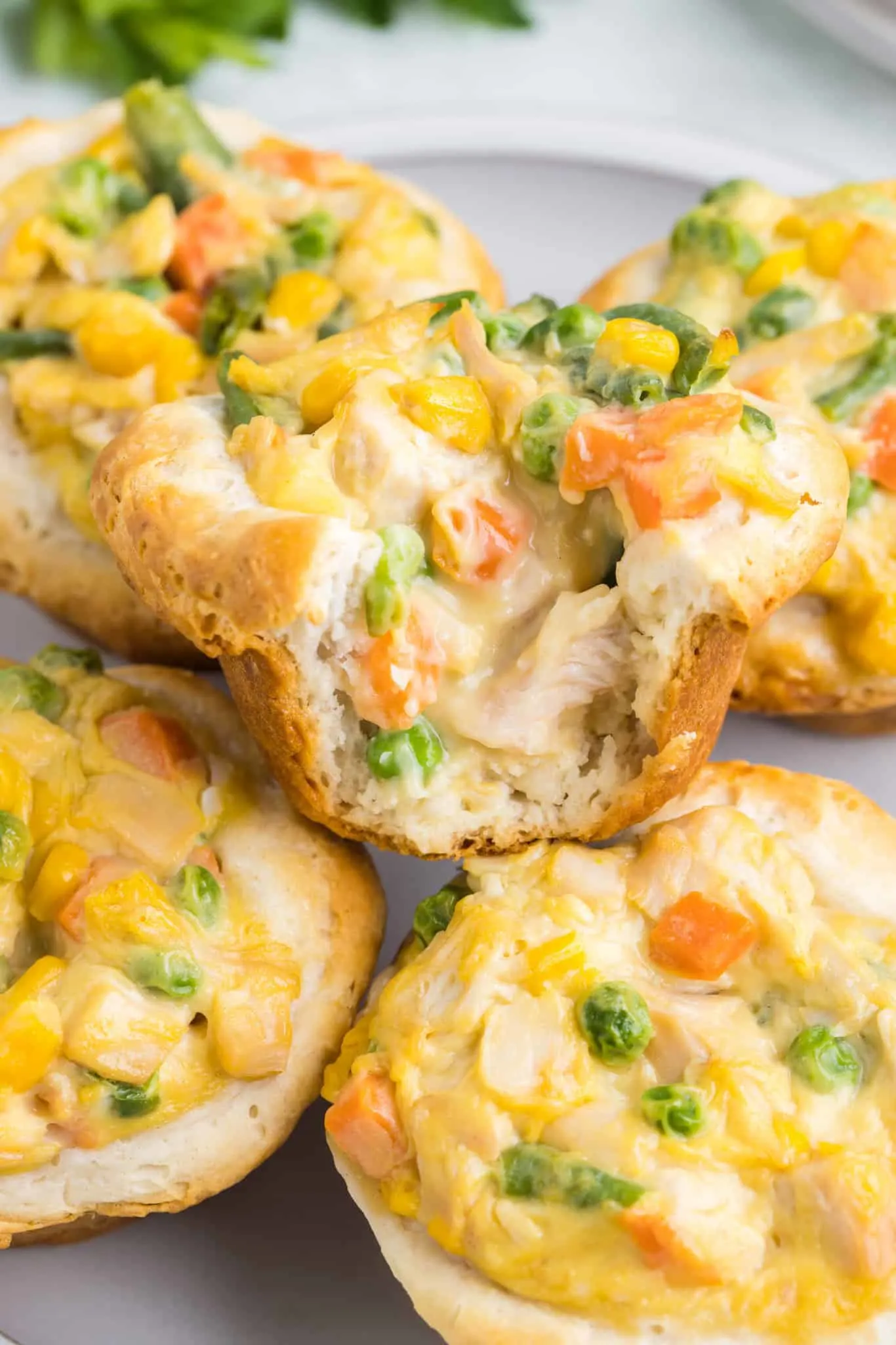 Mini Chicken Pot Pies are an easy dinner recipe using precooked chicken, frozen mixed vegetables, cream of chicken soup and Pillsbury refrigerated biscuits.