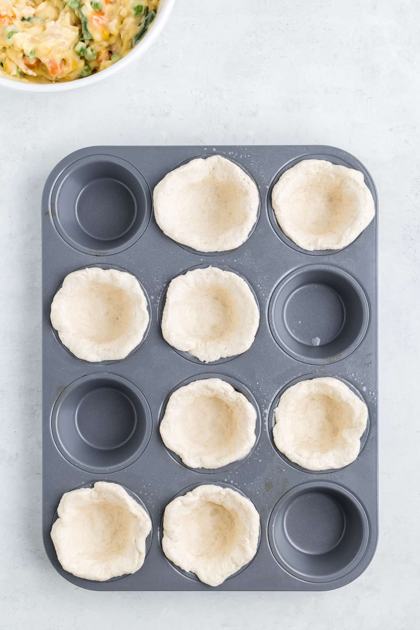 flattened biscuits pressed into muffin pan cups