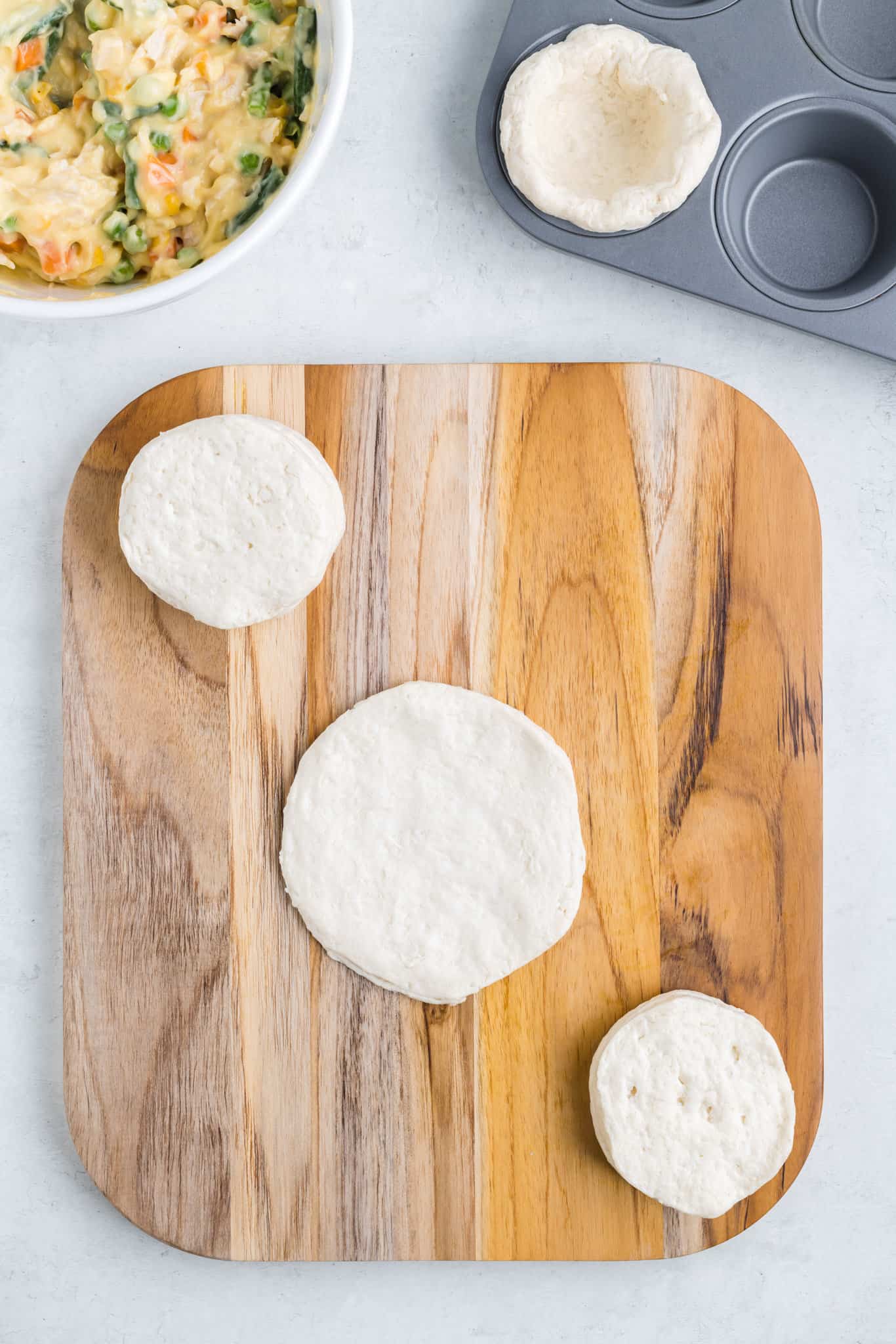 flattening biscuit dough on a cutting board