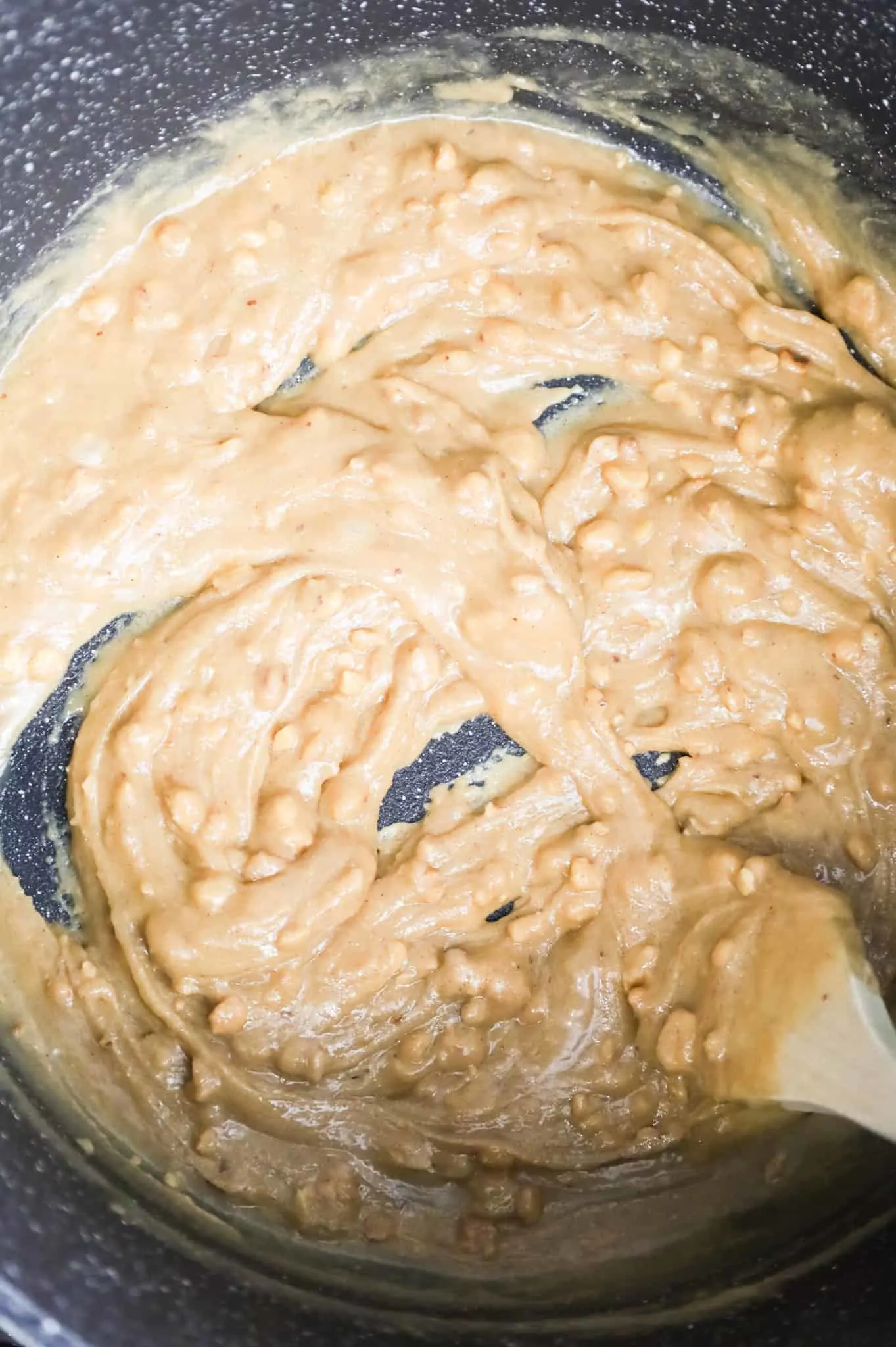 peanut butter, corn syrup and sugar being stirred together in a pot