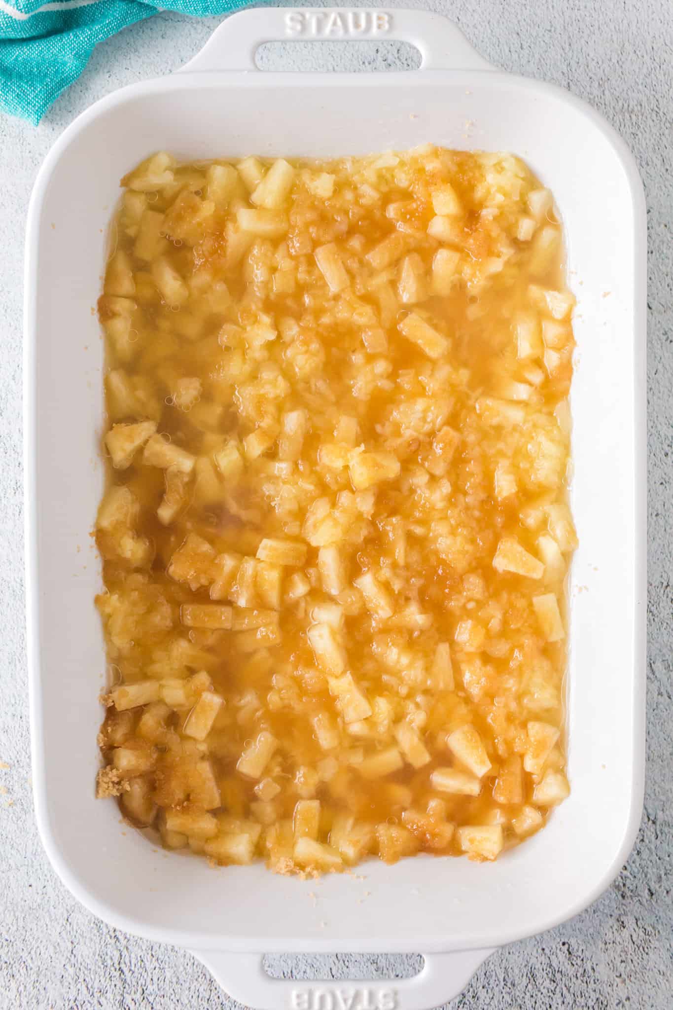 brown sugar on top of canned pineapple in a baking dish