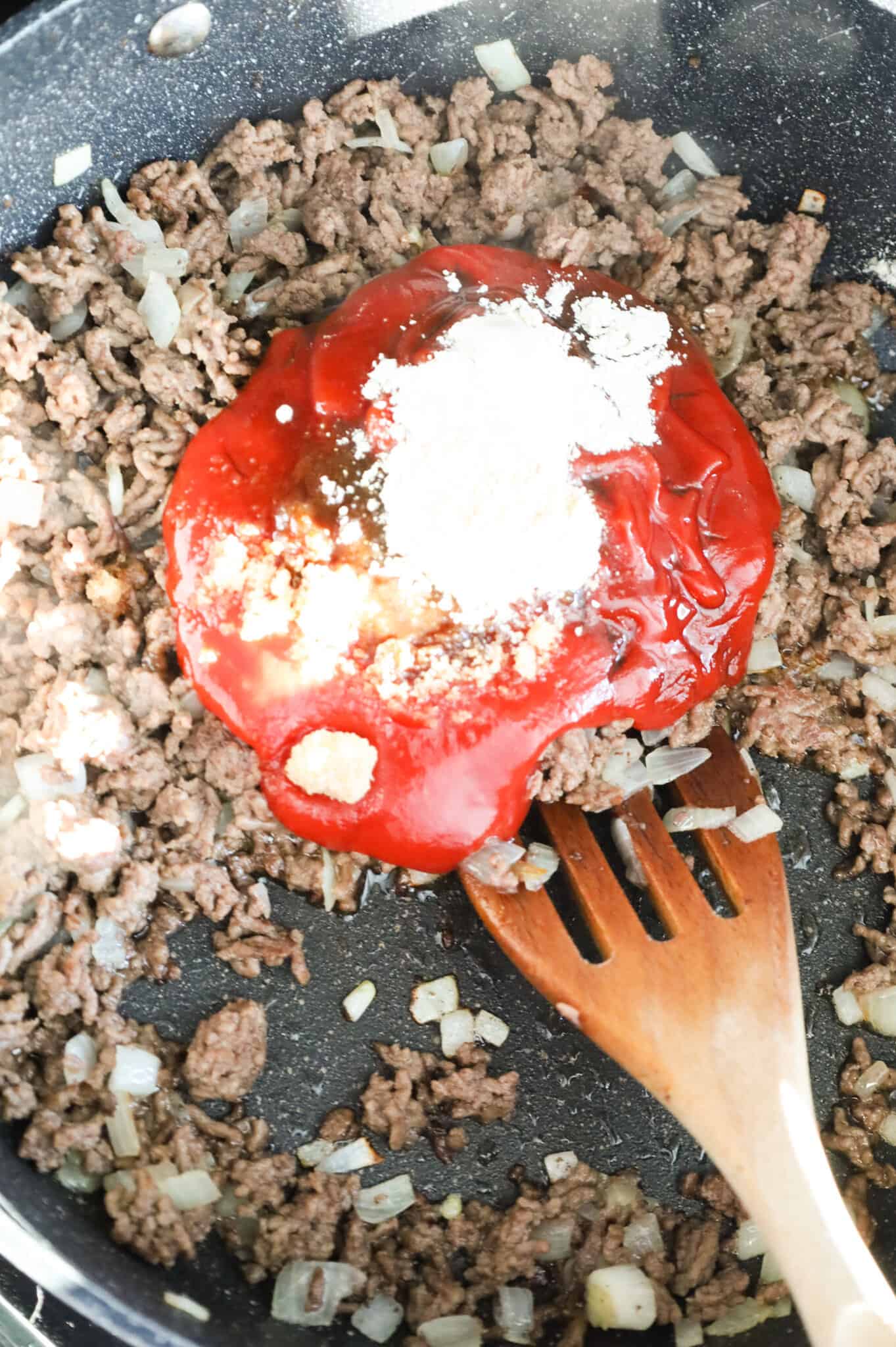 onion powder, garlic powder, brown sugar, Worcestershire sauce and ketchup on top of ground beef in a skillet