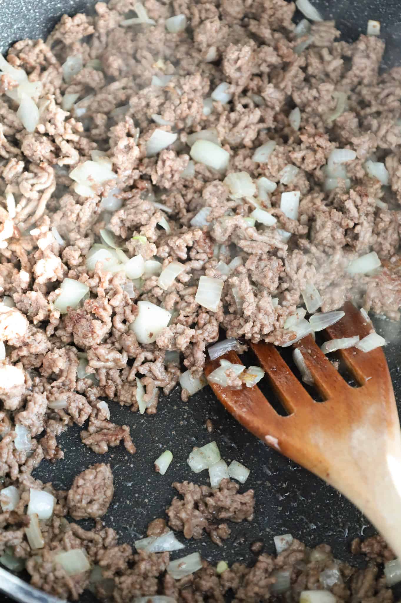 cooked ground beef and diced onions in a skillet