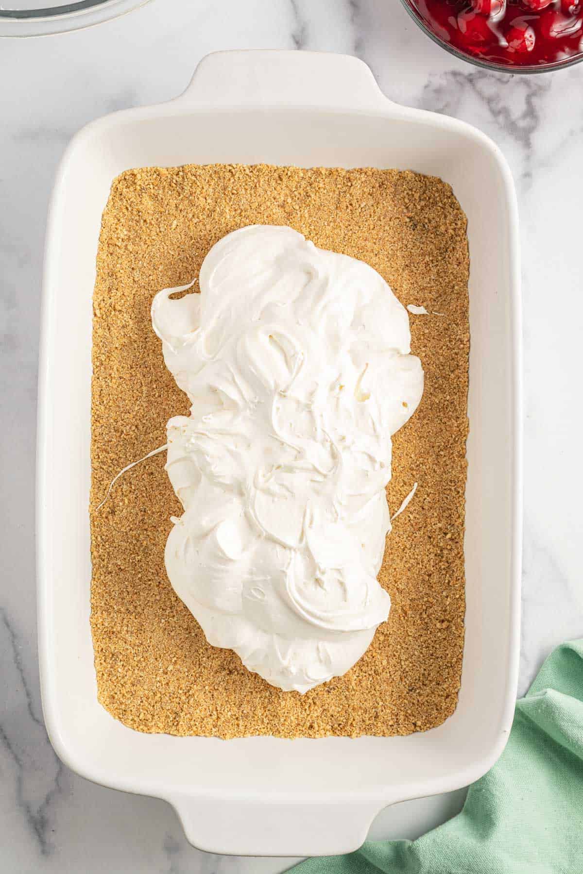 cream cheese mixture on top of graham crumb base in a baking dish
