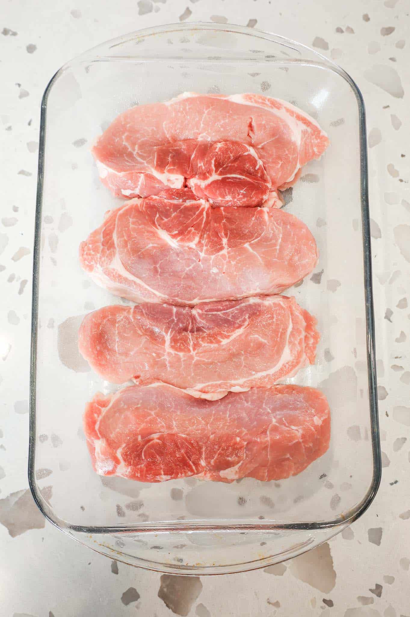 raw pork chops in a baking dish