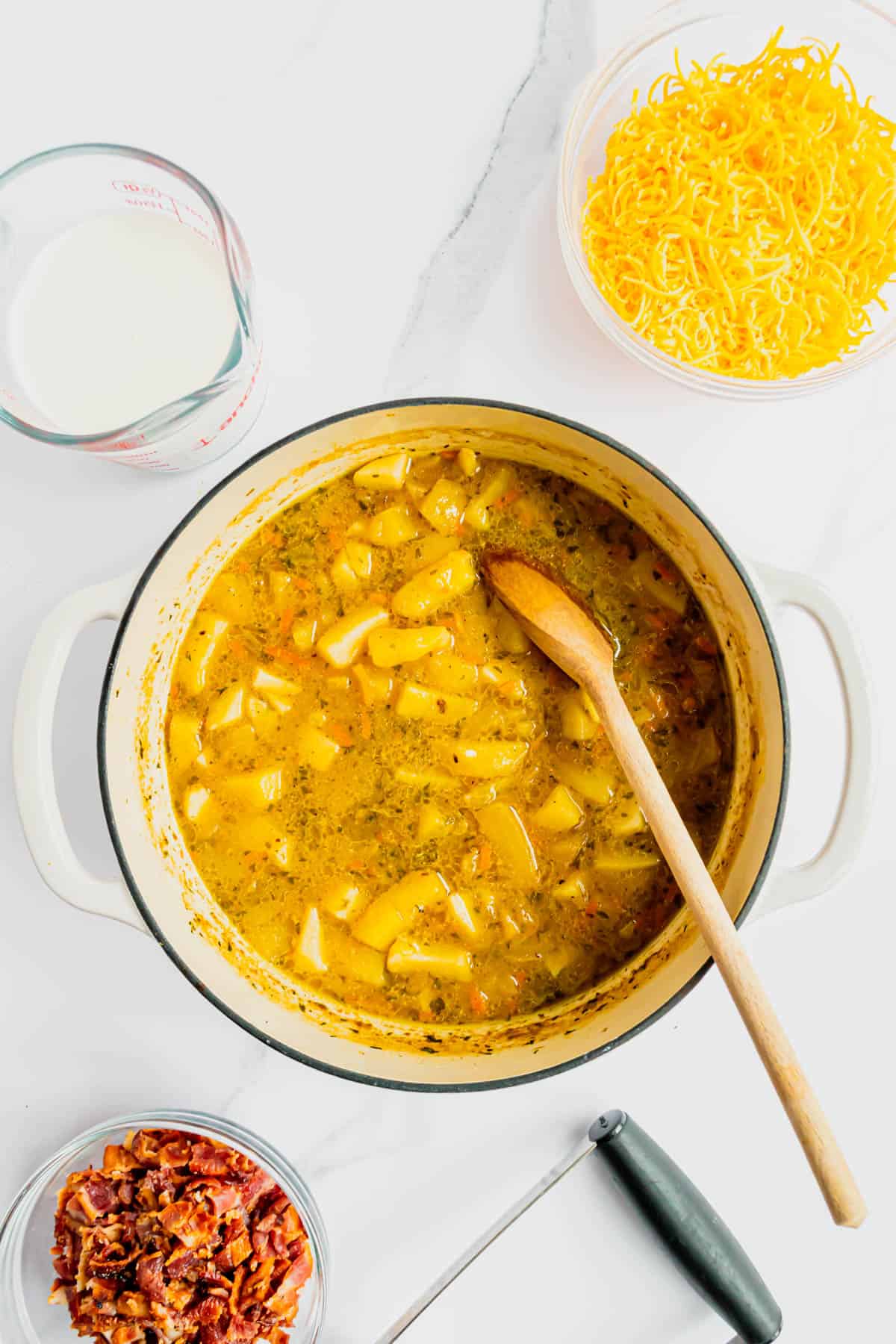 diced potatoes, chicken broth and seasonings added to Dutch oven with cooked veggies