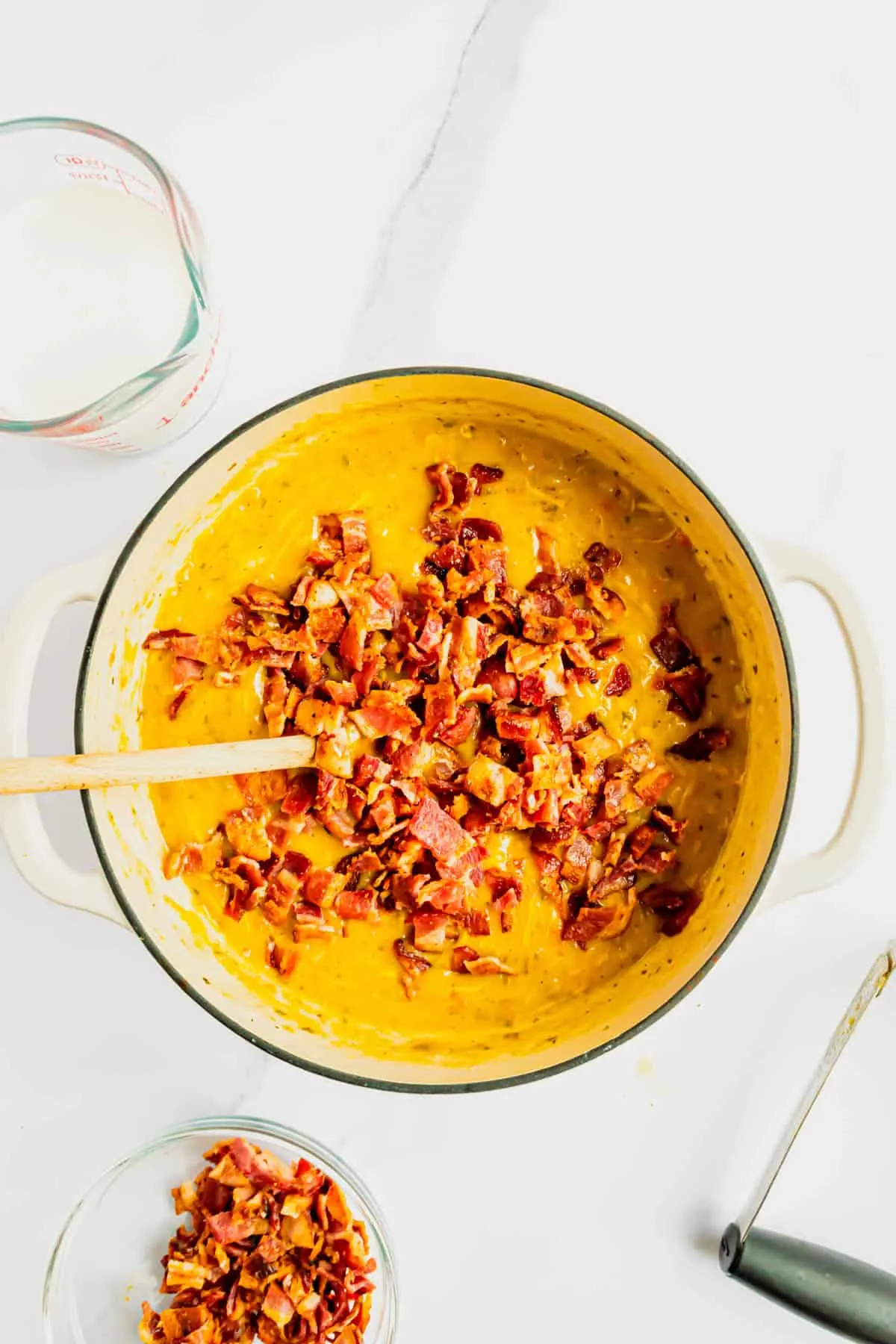 cooked bacon pieces on top of potato soup in a pot