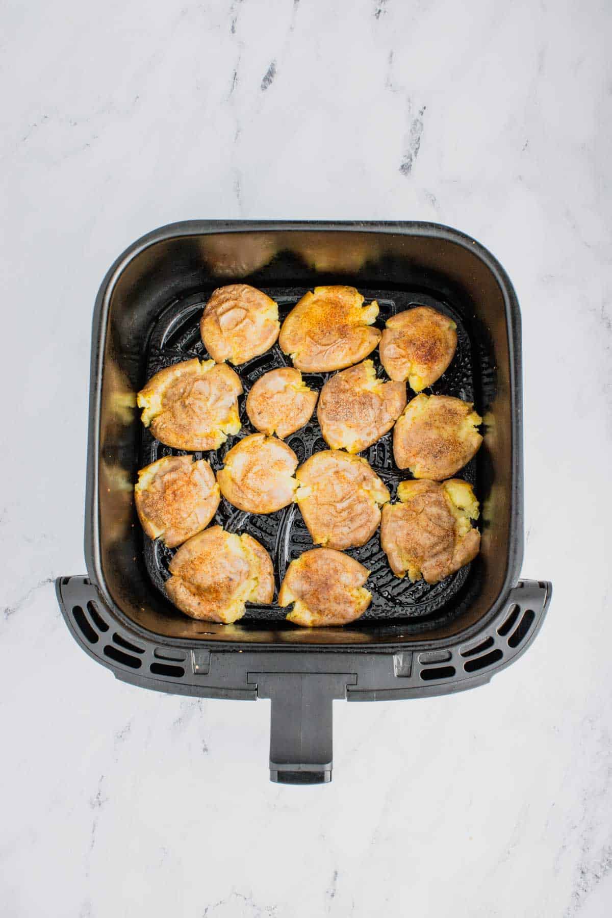 smashed potatoes in an air fryer basket