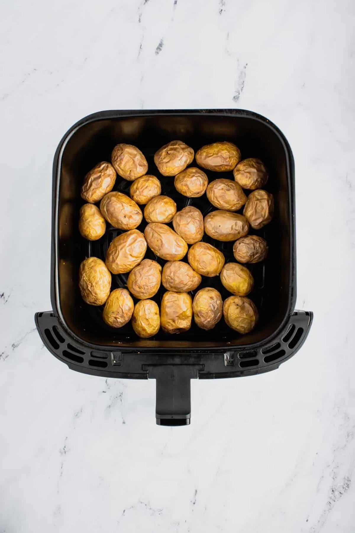 baby potatoes in an air fryer basket after cooking
