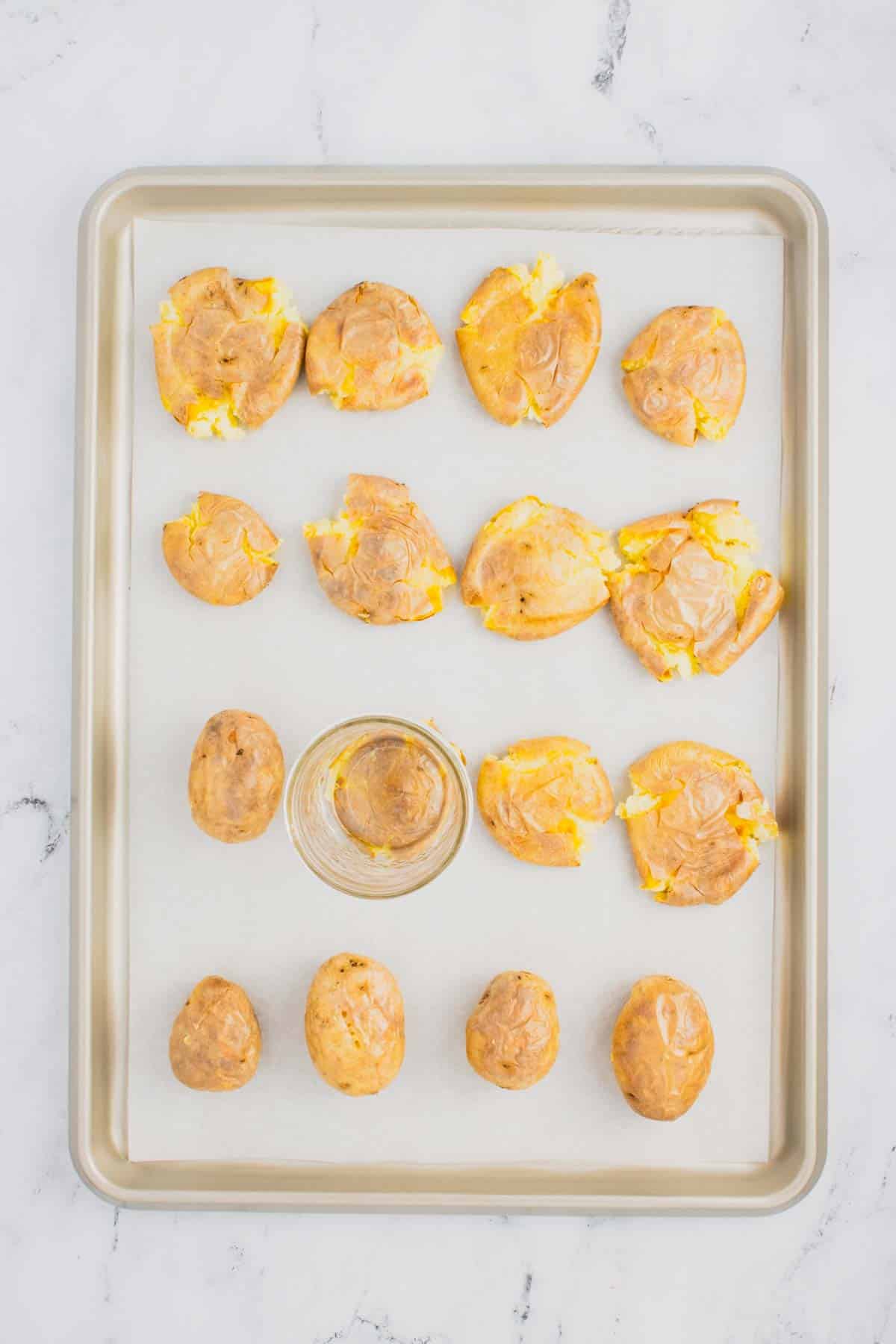 smashing potatoes on a parchment lined baking sheet