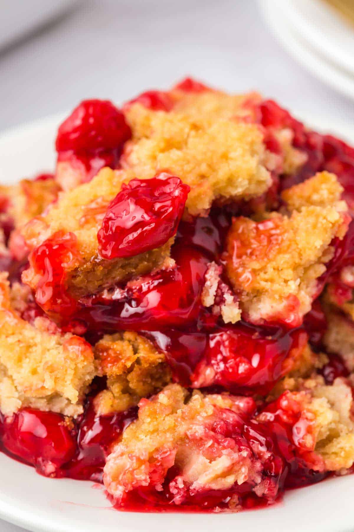 Cherry Dump Cake is an easy dessert recipe made with cherry pie filling, vanilla cake mix, crumbled butter cookies, vanilla extract and butter.