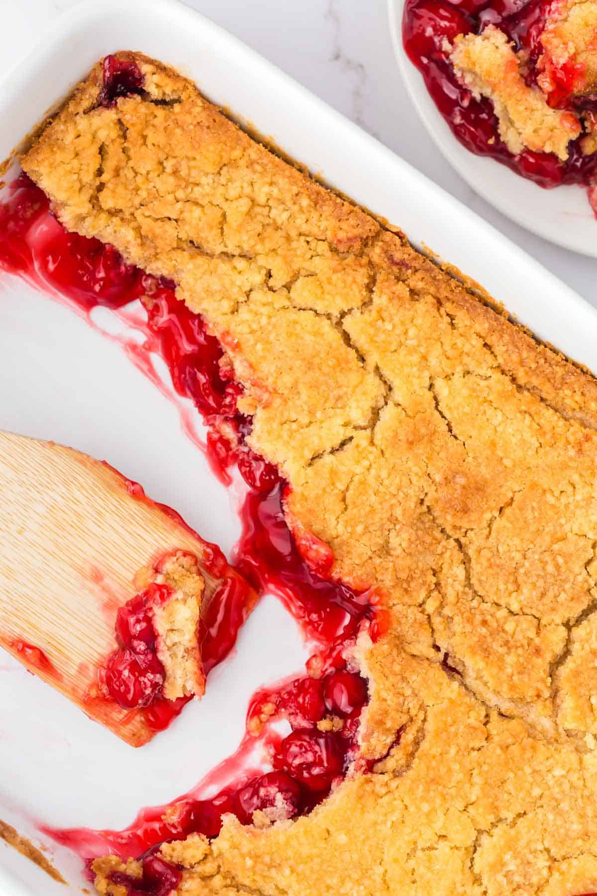 Cherry Dump Cake is an easy dessert recipe made with cherry pie filling, vanilla cake mix, crumbled butter cookies, vanilla extract and butter.