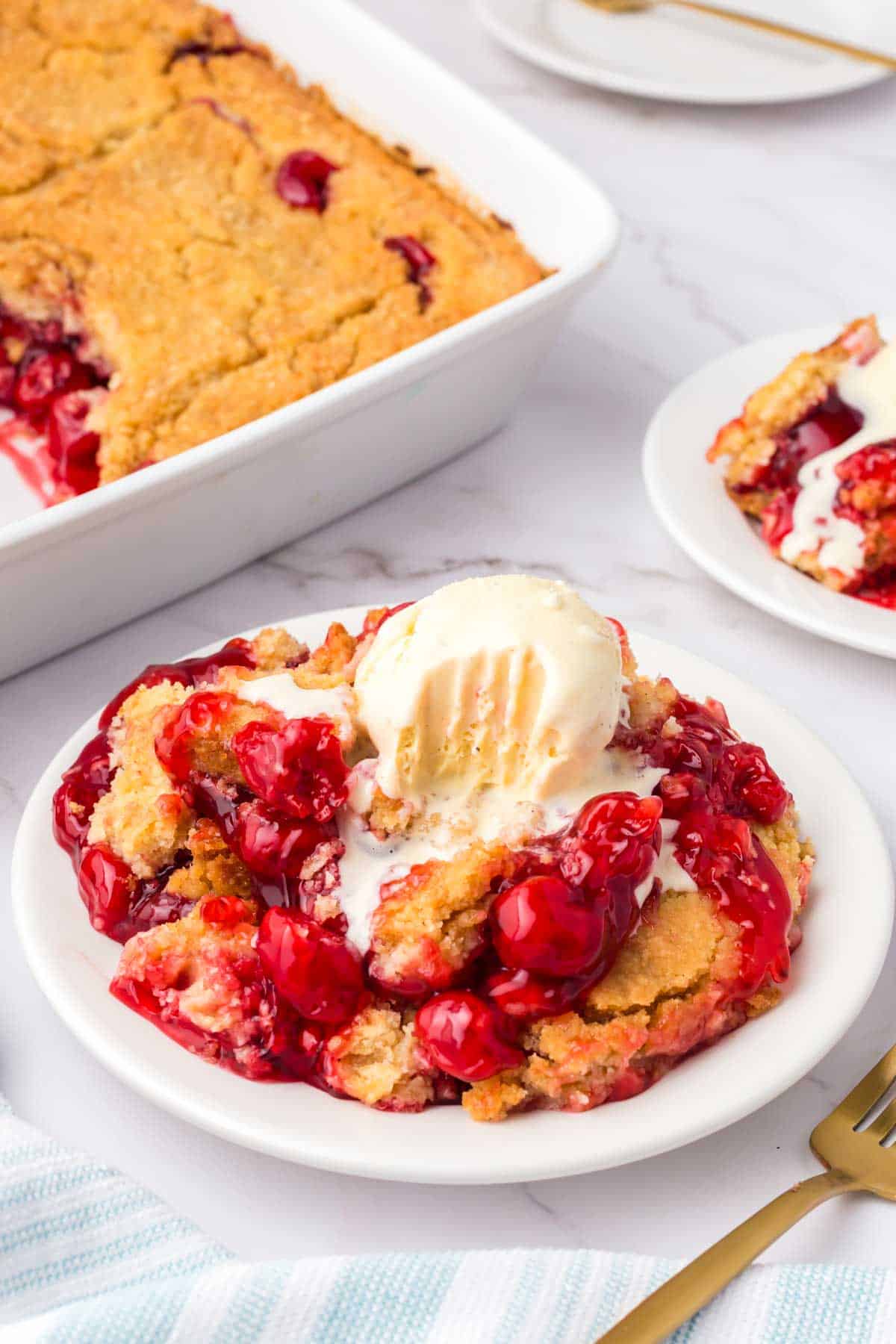 Cherry Dump Cake is an easy dessert recipe made with cherry pie filling, vanilla cake mix, crumbled butter cookies, vanilla extract and butter.