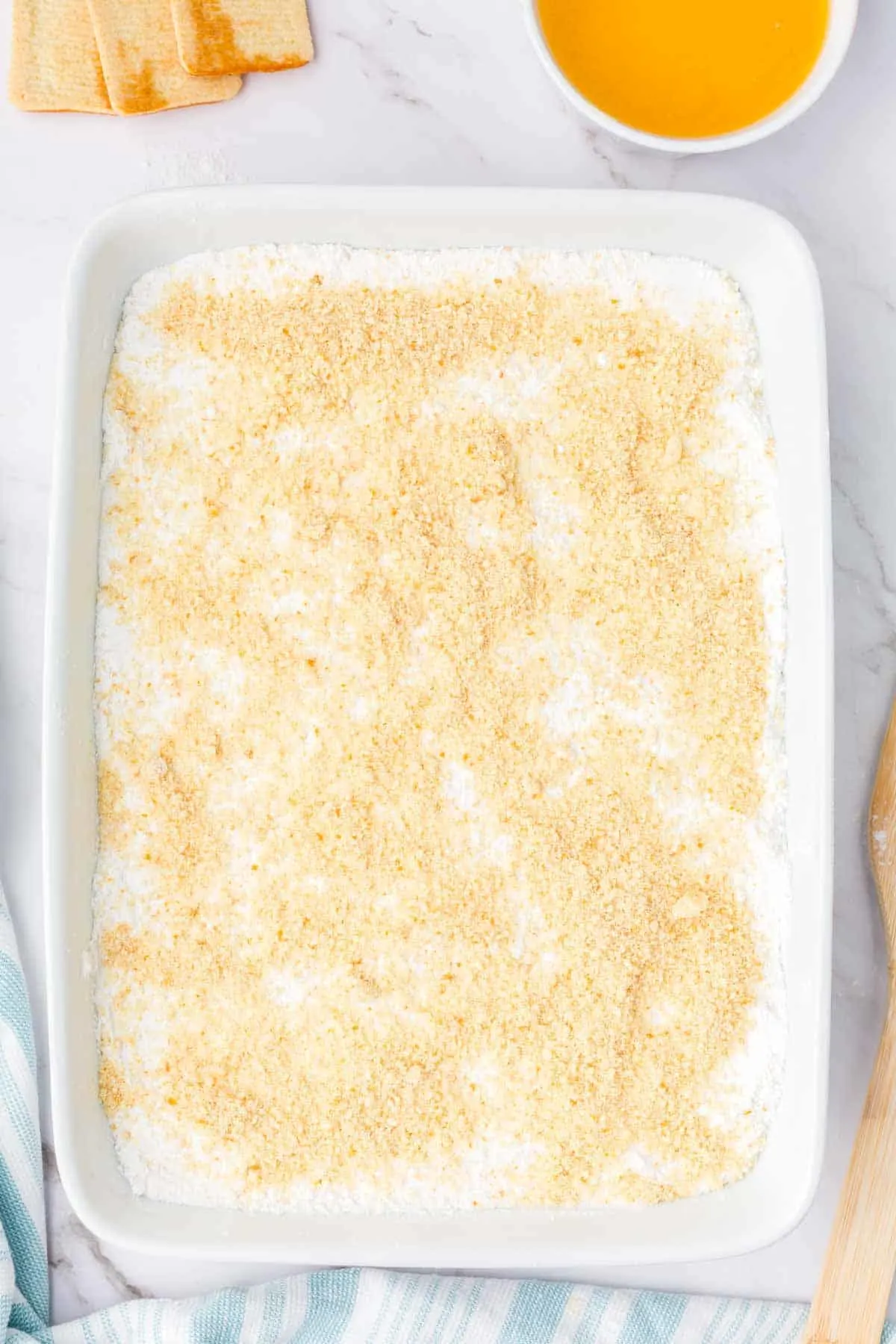 butter cookie crumbs sprinkled on top of vanilla cake mix in a baking dish