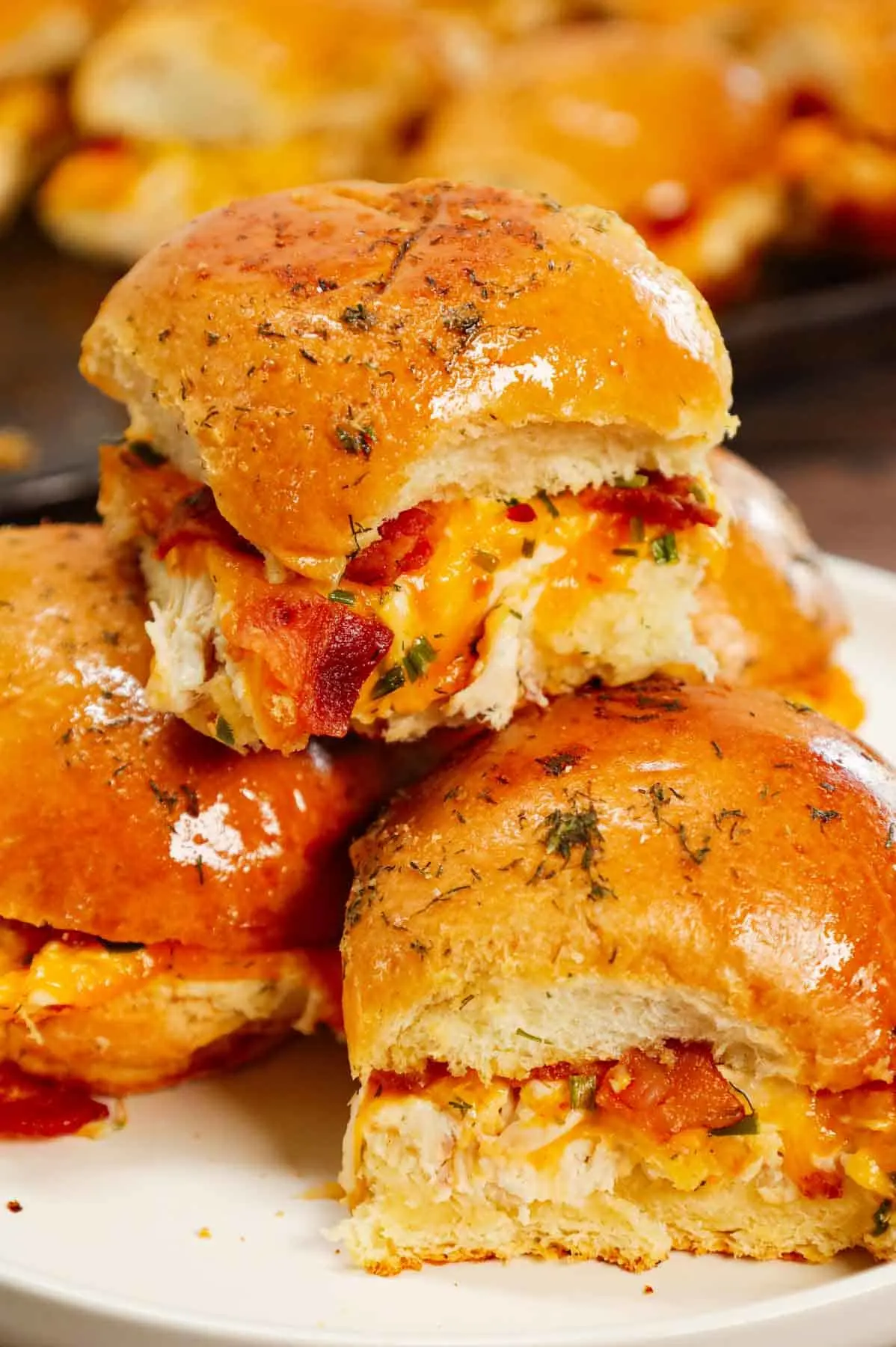 Chicken Bacon Ranch Sliders are the perfect handheld sandwich loaded with shredded rotisserie chicken, crumbled bacon, ranch dressing, chives and cheddar cheese.