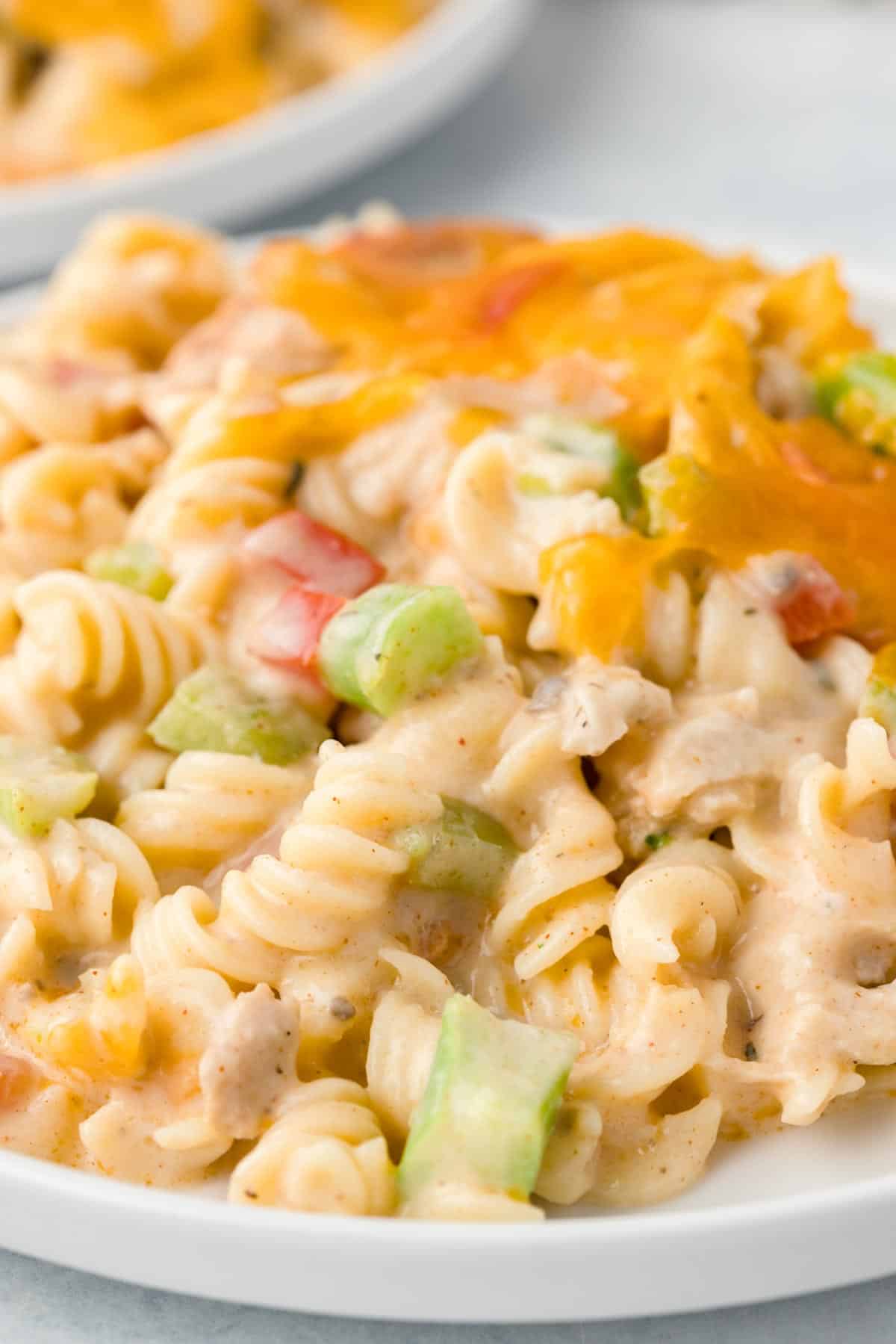 Chicken Pasta Casserole is a creamy casserole loaded with chunks of chicken, rotini noodles, mixed vegetables, cream of mushroom soup, cream of chicken soup and cheddar cheese.