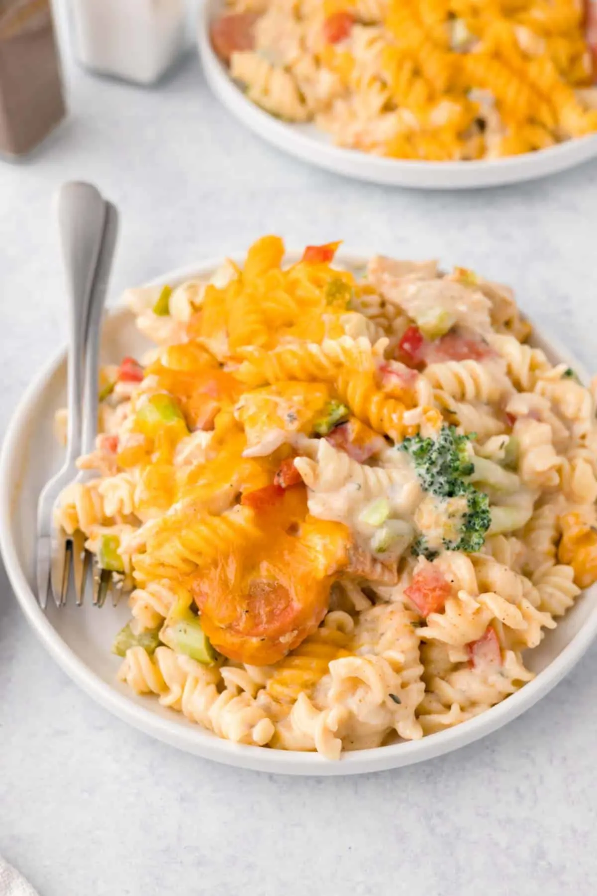 Chicken Pasta Casserole is a creamy casserole loaded with chunks of chicken, rotini noodles, mixed vegetables, cream of mushroom soup, cream of chicken soup and cheddar cheese.