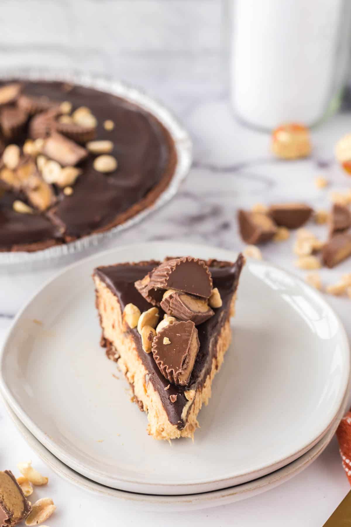 Chocolate Peanut Butter Pie is an easy no bake dessert recipe using a store bought chocolate pie crust with a creamy peanut butter cream cheese filling all topped with chocolate ganache, chopped Reese's peanut butter cups and peanuts.