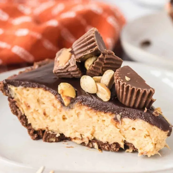 Chocolate Peanut Butter Pie is an easy no bake dessert recipe using a store bought chocolate pie crust with a creamy peanut butter cream cheese filling all topped with chocolate ganache, chopped Reese's peanut butter cups and peanuts.