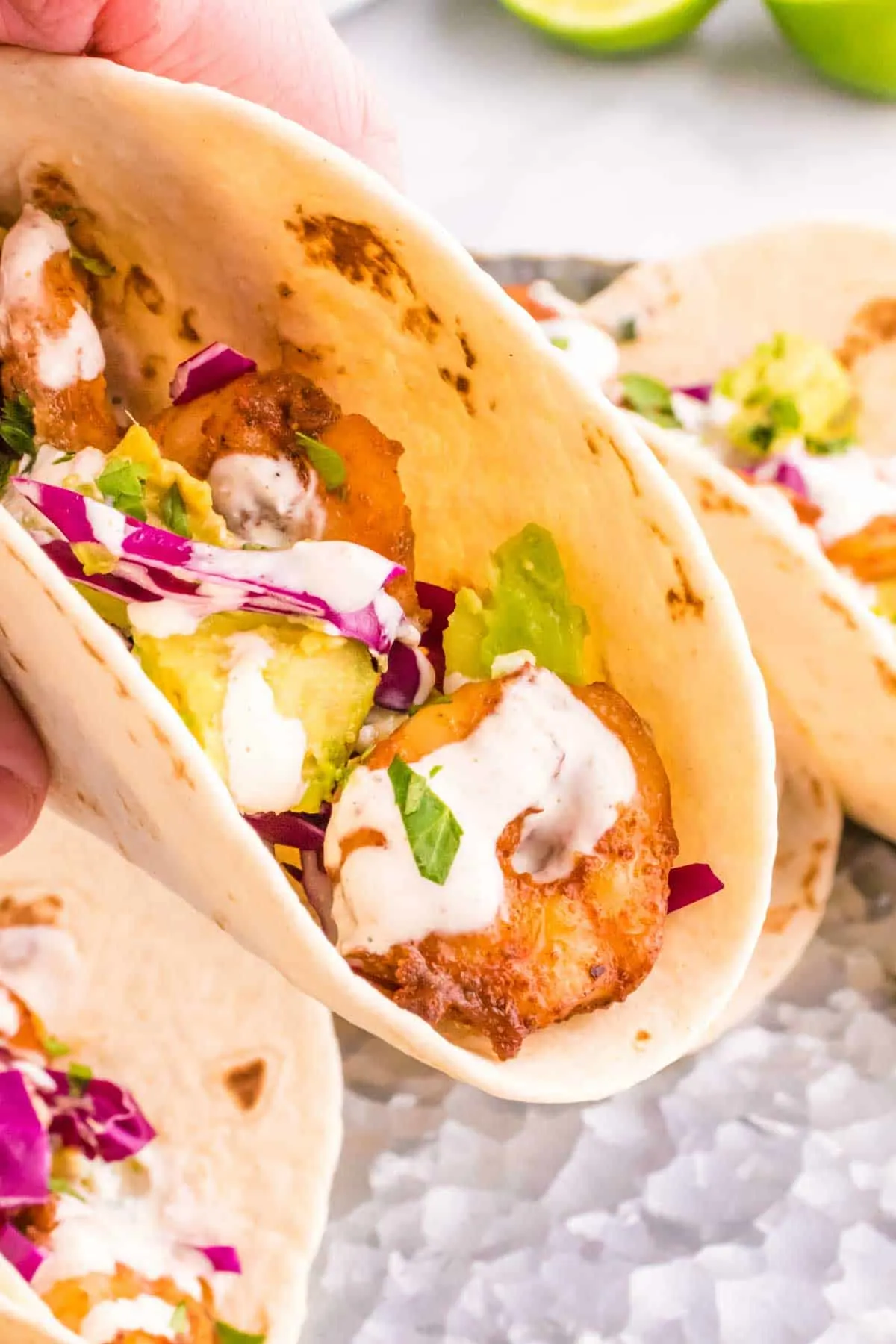 Cilantro Lime Shrimp Tacos are tasty tacos with seasoned shrimp, sliced red cabbage, diced avocados and a creamy dressing made with mayo, Greek yogurt, lime juice and cilantro.