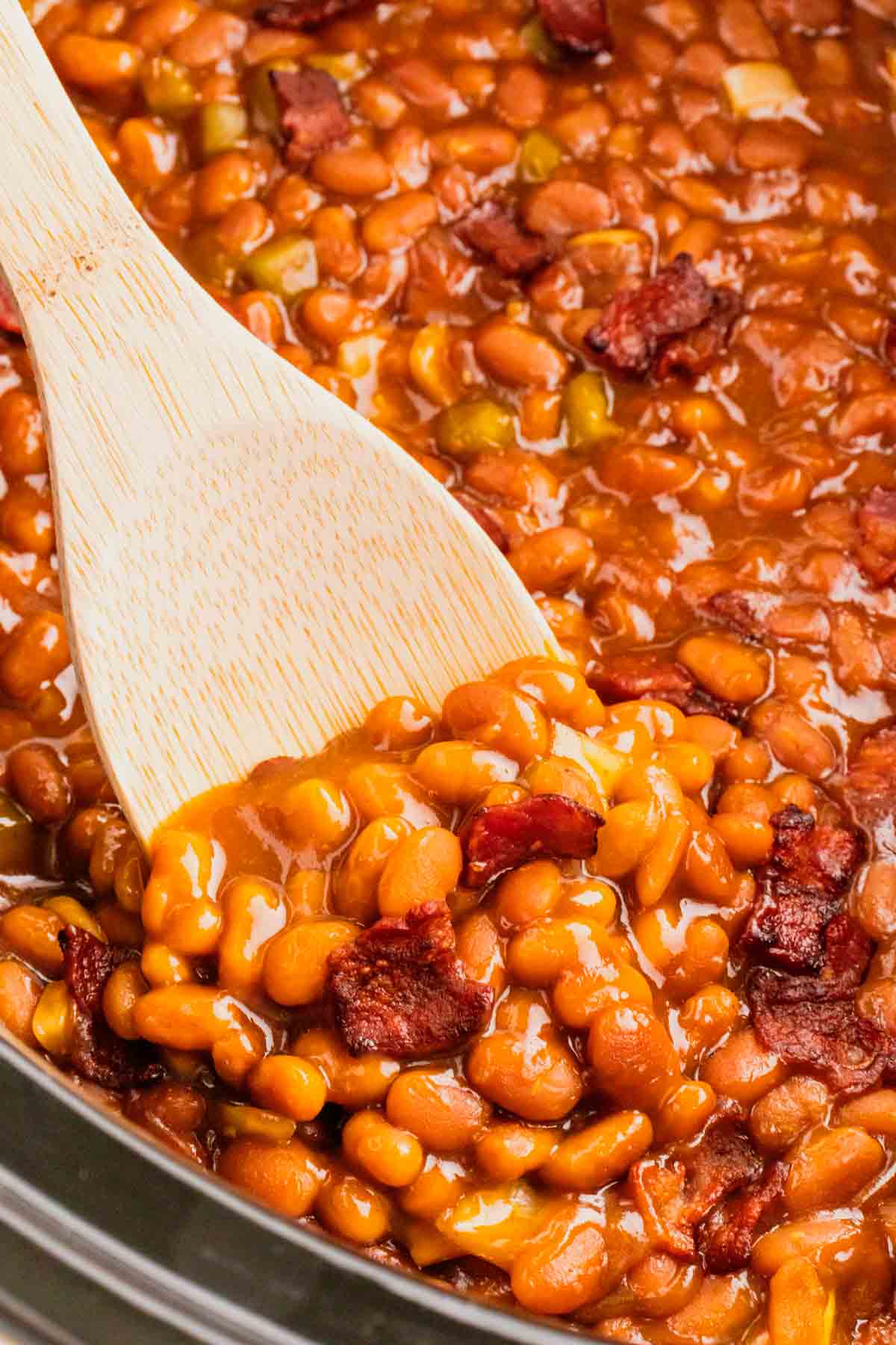 Crock Pot Baked Beans are a simple slow cooker side dish recipe made with canned baked beans, barbecue sauce, ketchup, brown sugar, bell peppers, onions and bacon.