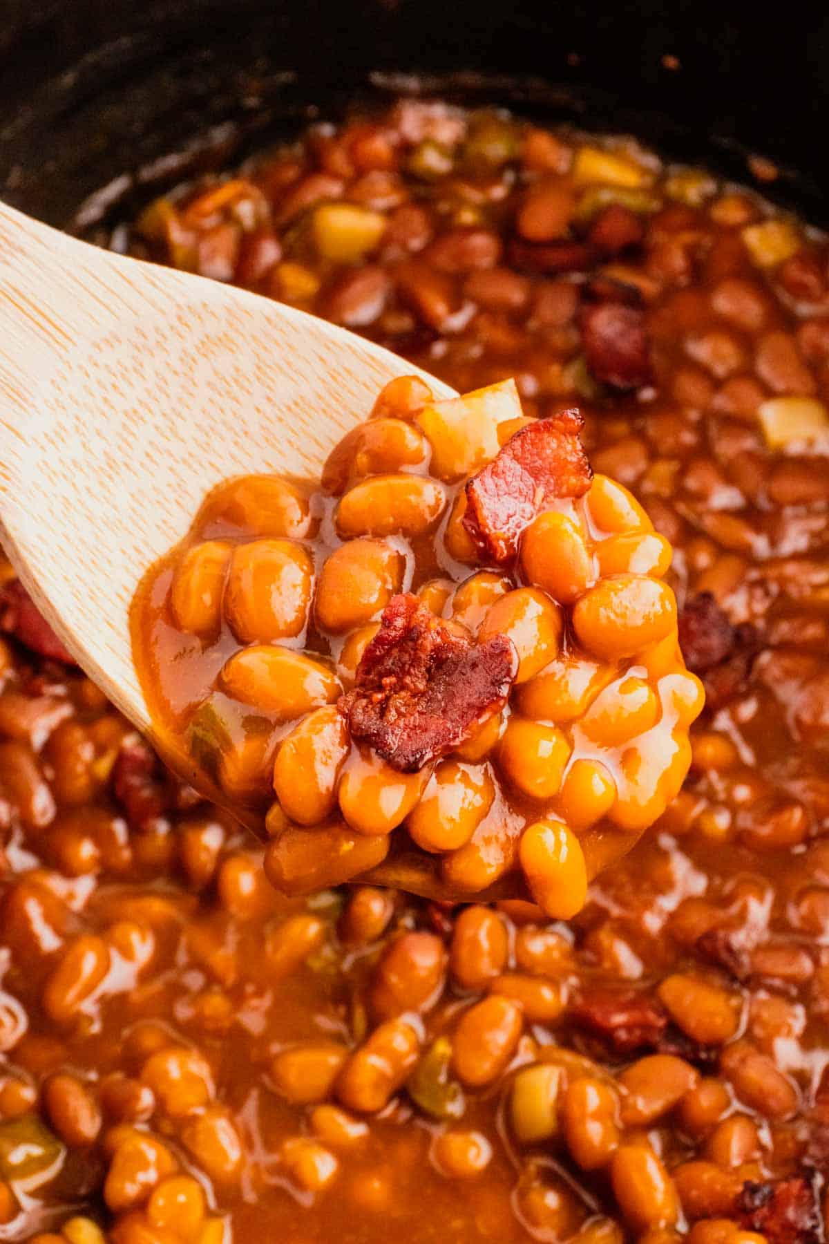 Crock Pot Baked Beans are a simple slow cooker side dish recipe made with canned baked beans, barbecue sauce, ketchup, brown sugar, bell peppers, onions and bacon.