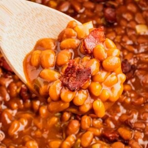 Crock Pot Baked Beans are a simple slow cooker side dish recipe made with canned baked beans, barbecue sauce, ketchup, brown sugar, bell peppers, onions and bacon.