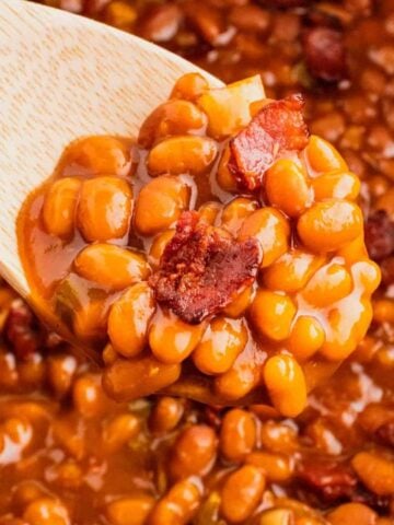 Crock Pot Baked Beans are a simple slow cooker side dish recipe made with canned baked beans, barbecue sauce, ketchup, brown sugar, bell peppers, onions and bacon.