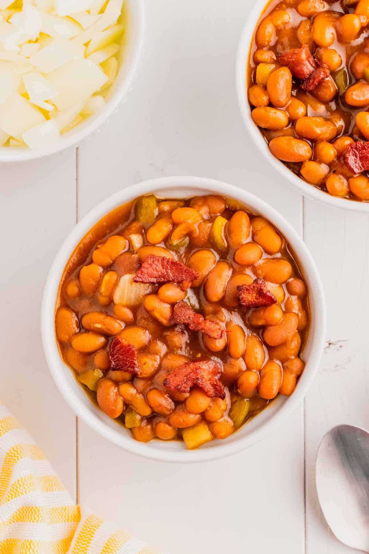 Crock Pot Baked Beans are a simple slow cooker side dish recipe made with canned baked beans, barbecue sauce, ketchup, brown sugar, bell peppers, onions and bacon.