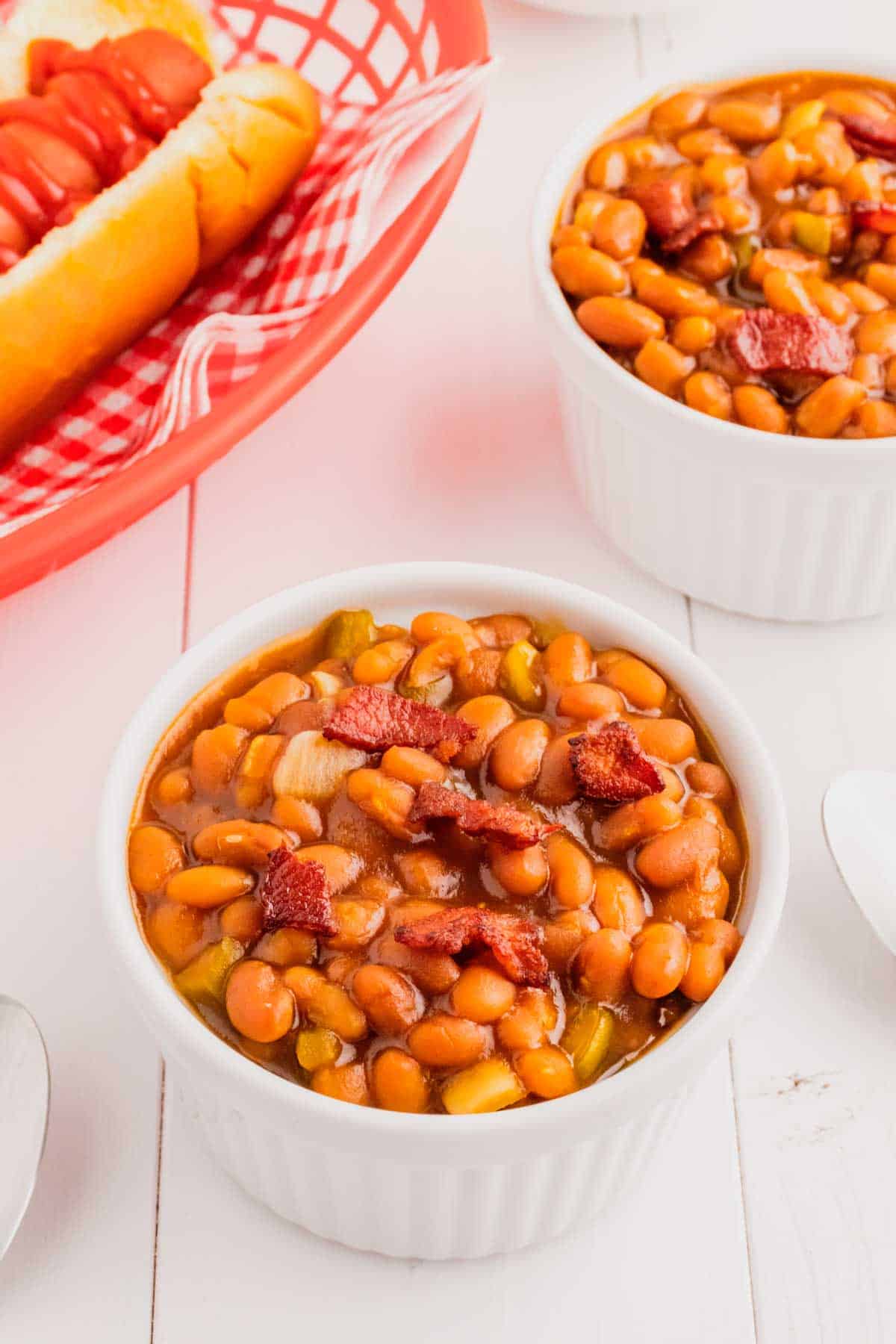 Crock Pot Baked Beans are a simple slow cooker side dish recipe made with canned baked beans, barbecue sauce, ketchup, brown sugar, bell peppers, onions and bacon.