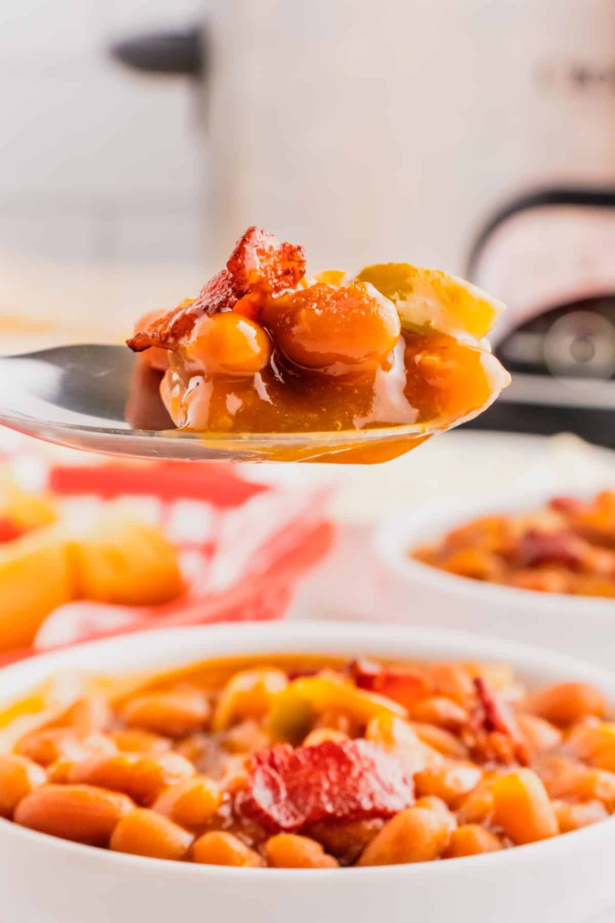 Crock Pot Baked Beans are a simple slow cooker side dish recipe made with canned baked beans, barbecue sauce, ketchup, brown sugar, bell peppers, onions and bacon.