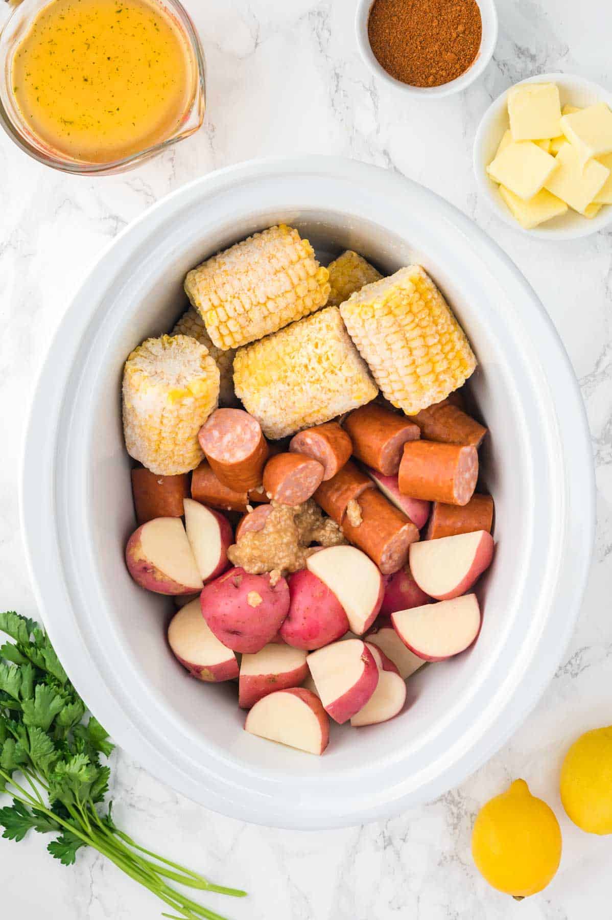 minced garlic, sliced sausage, potatoes and corn on the cob in a crock pot