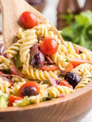 Greek Pasta Salad is a colourful pasta salad recipe loaded with cucumbers, red bell peppers, grape tomatoes, red onions, Kalamata olives and feta cheese all tossed in a homemade dressing.