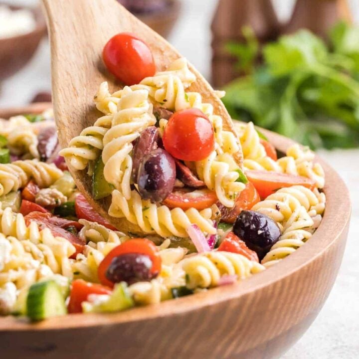 Greek Pasta Salad is a colourful pasta salad recipe loaded with cucumbers, red bell peppers, grape tomatoes, red onions, Kalamata olives and feta cheese all tossed in a homemade dressing.