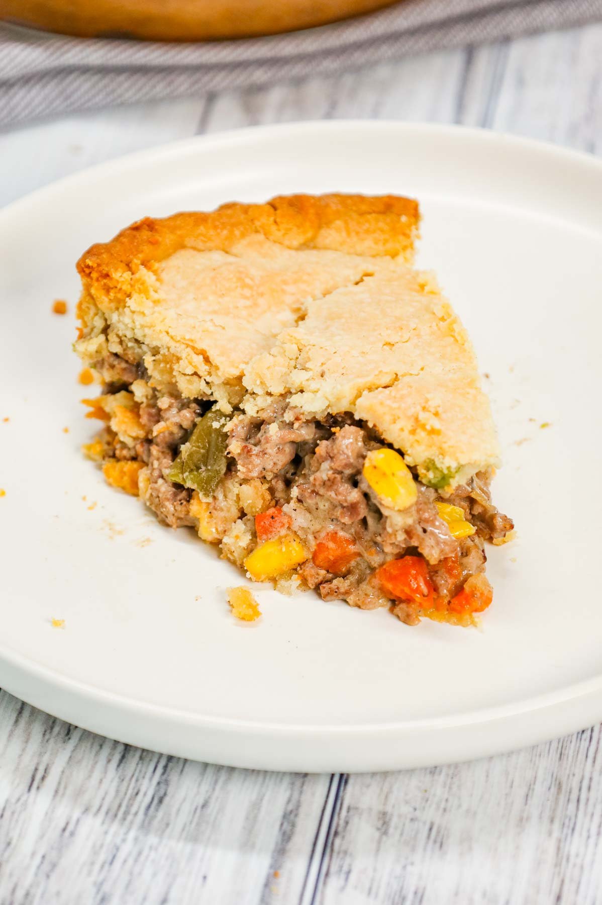 Ground Beef Pot Pie is an easy weeknight dinner recipe made with store bought pie crust and filled with ground beef and mixed vegetables all tossed in cream of mushroom soup.