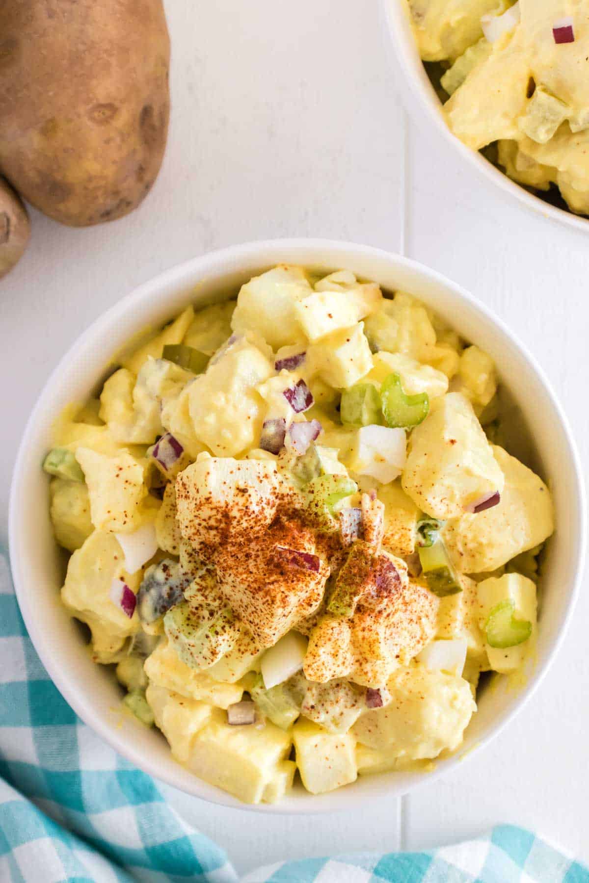 Southern Potato Salad is a classic side dish recipe loaded with cubes of russet potatoes, chopped hard boiled eggs, celery, red onions and dill pickles all tossed in a mayo based dressing and seasoned with paprika.