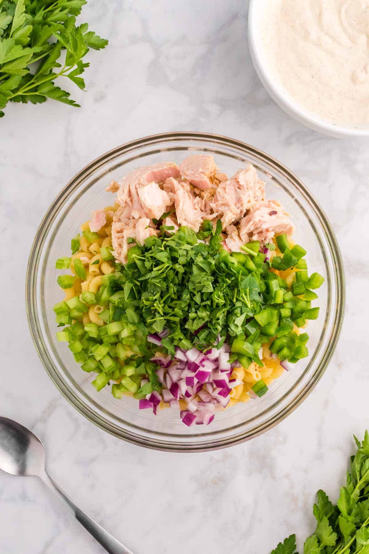 fresh parsley, red onions, celery, green peppers, tuna chunks and macaroni in a bowl