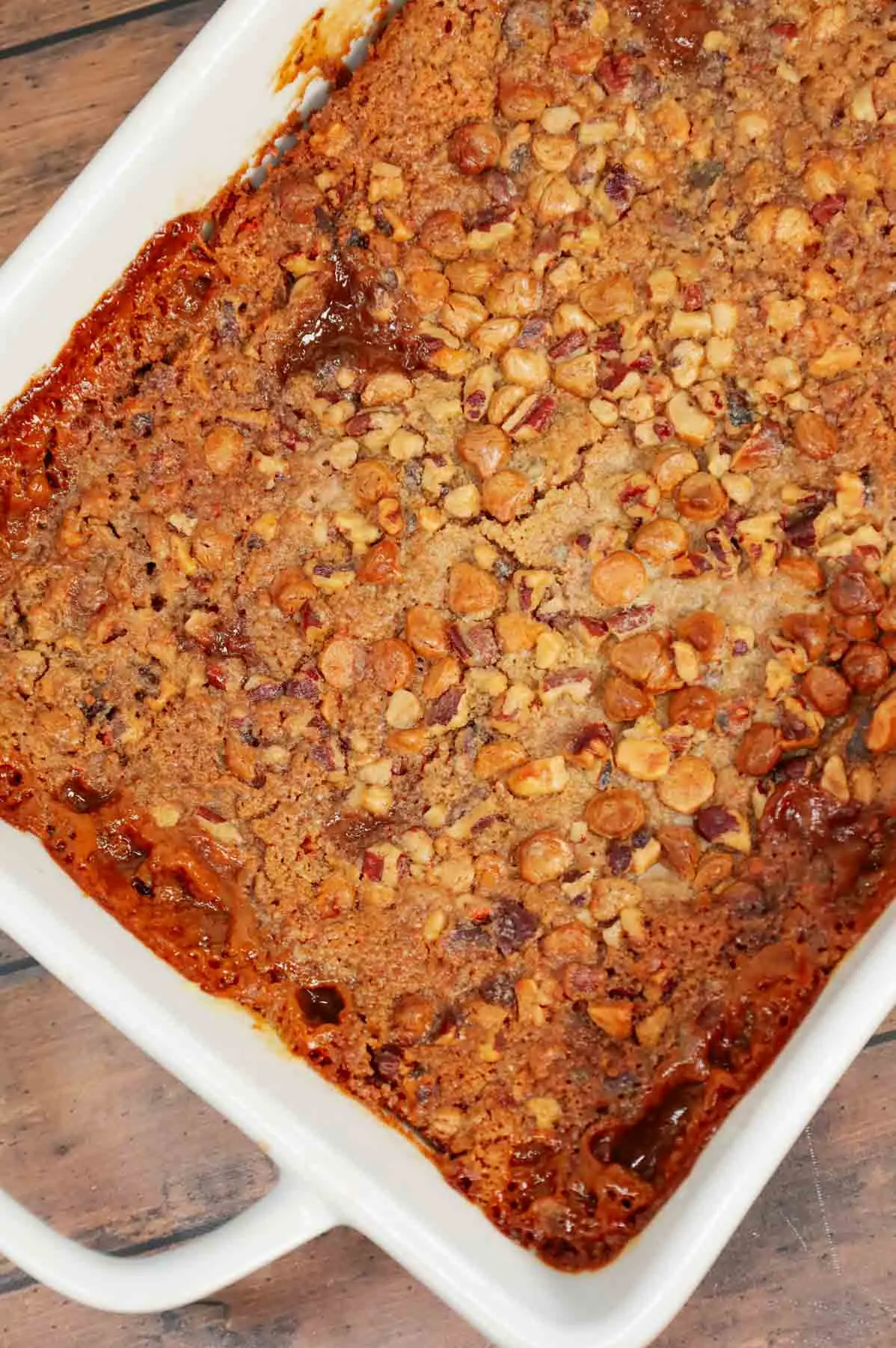 Carrot Dump Cake is an easy and decadent dessert recipe using freshly grated carrot, canned dulce de leche, store bought cream cheese frosting, boxed carrot cake mix, cream cheese flavoured baking chips, chopped pecans and melted butter.