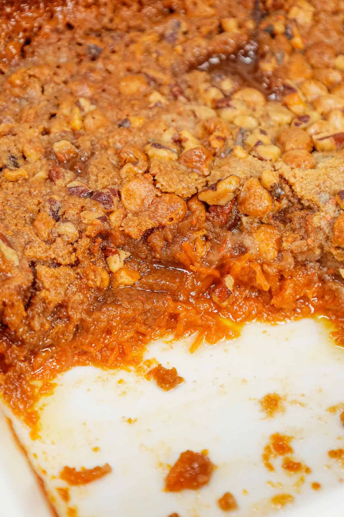 Carrot Dump Cake is an easy and decadent dessert recipe using freshly grated carrot, canned dulce de leche, store bought cream cheese frosting, boxed carrot cake mix, cream cheese flavoured baking chips, chopped pecans and melted butter.