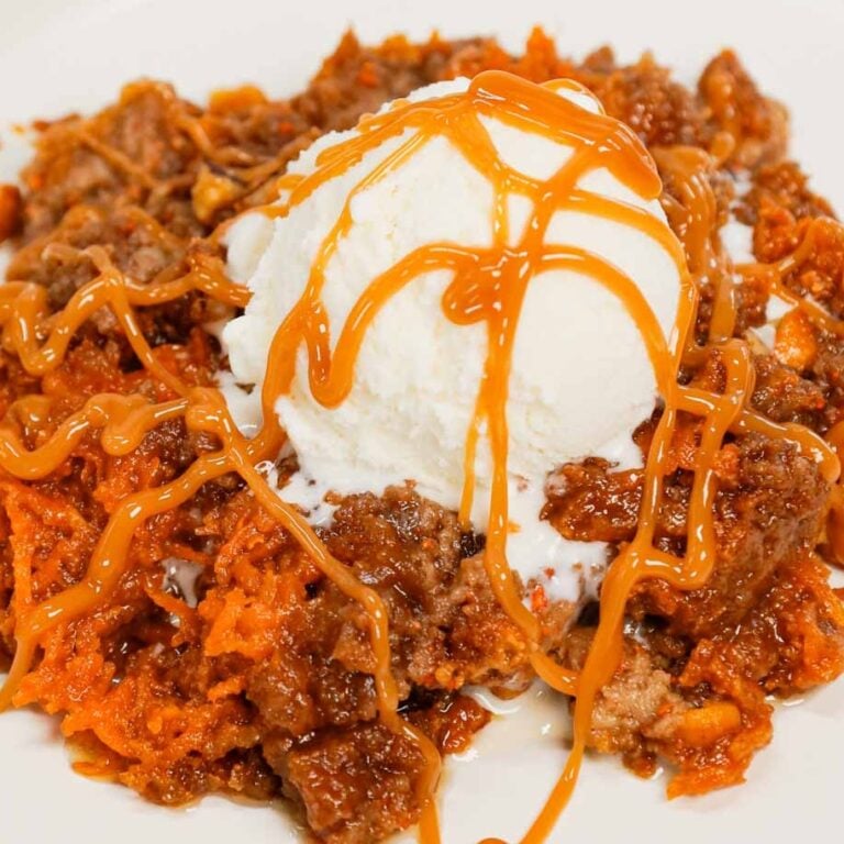 Carrot Dump Cake is an easy and decadent dessert recipe using freshly grated carrot, canned dulce de leche, store bought cream cheese frosting, boxed carrot cake mix, cream cheese flavoured baking chips, chopped pecans and melted butter.