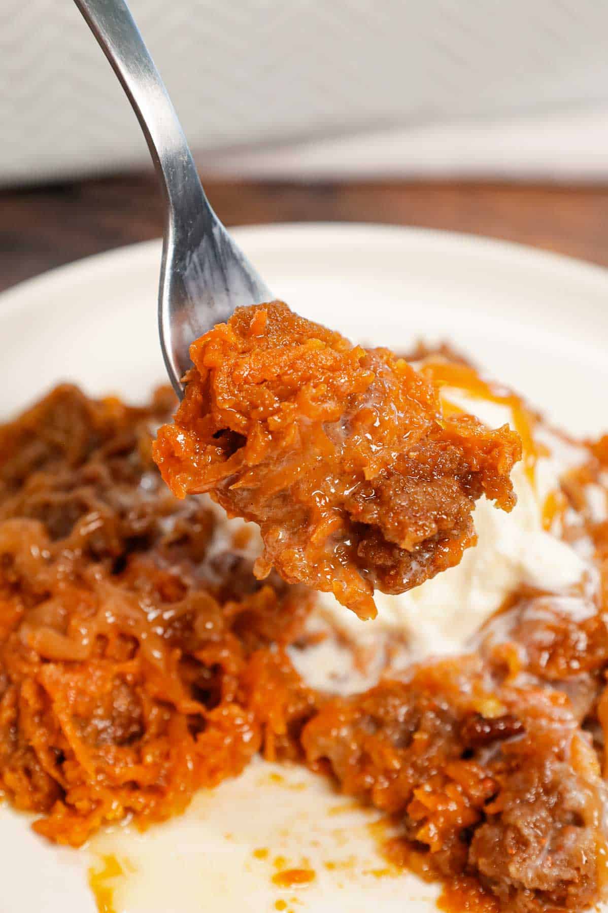 Carrot Dump Cake is an easy and decadent dessert recipe using freshly grated carrot, canned dulce de leche, store bought cream cheese frosting, boxed carrot cake mix, cream cheese flavoured baking chips, chopped pecans and melted butter.