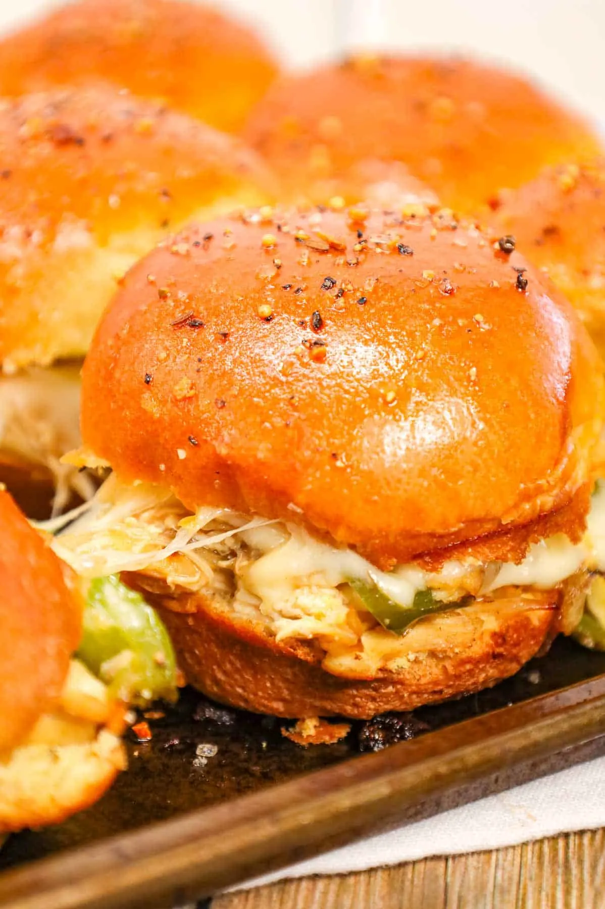 Chicken Philly Sliders are delicious mini sandwiches on brioche dinner rolls loaded with shredded chicken, green bell peppers, onions and Provolone cheese.