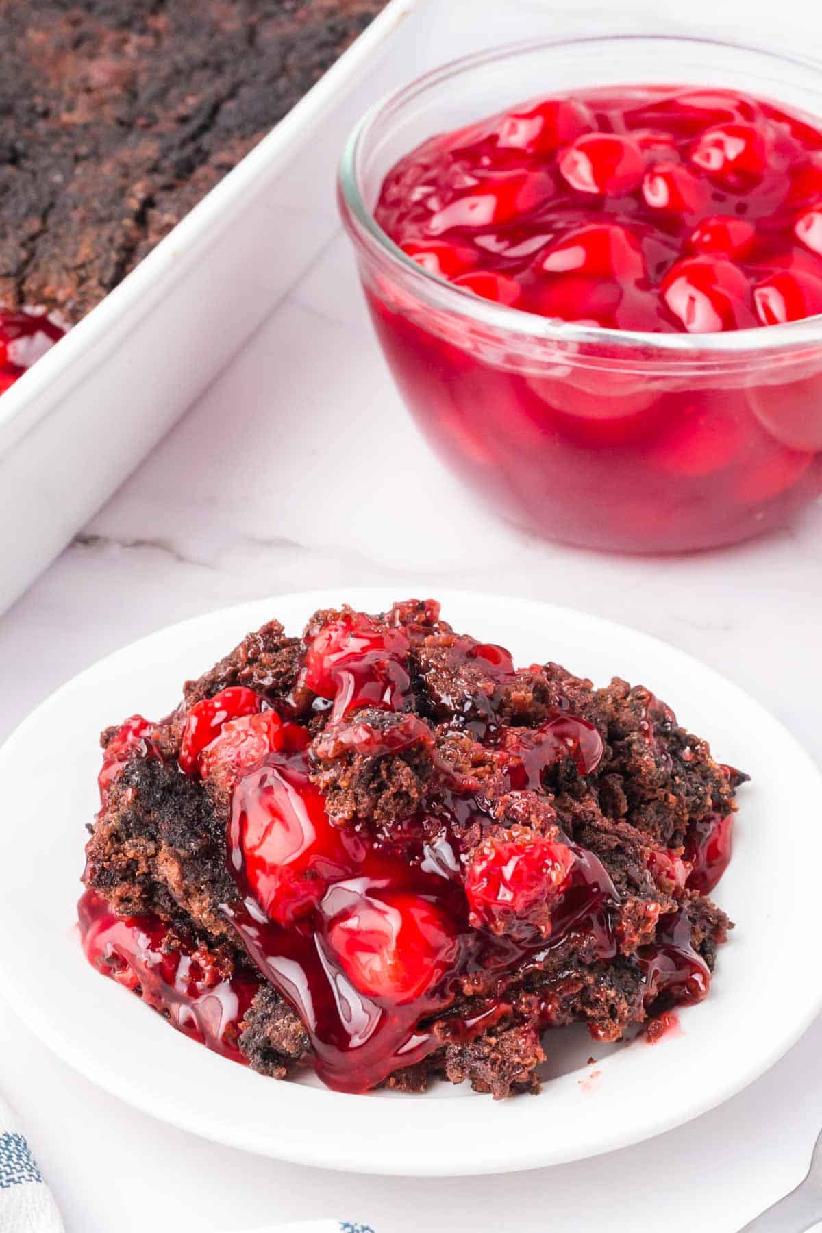 Chocolate Cherry Dump Cake is an easy dessert recipe made with cherry pie filling, Devils Food chocolate cake mix, butter and Oreo thins cookies.