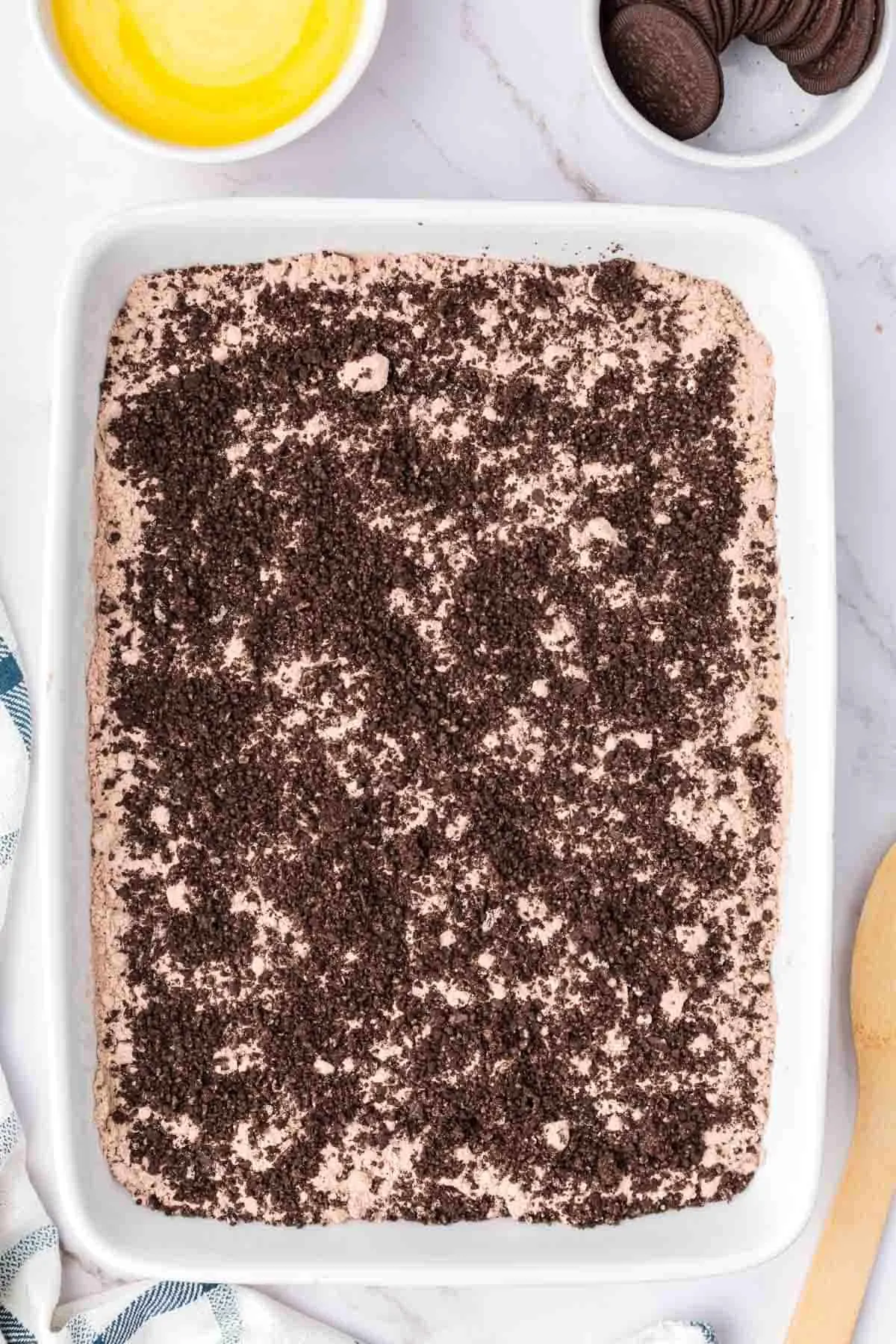 Oreo cookie crumbs over Devils food cake mix in a baking dish