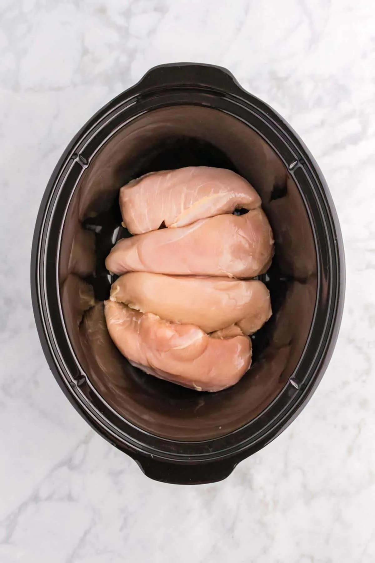 raw boneless, skinless chicken breasts in a Crock Pot