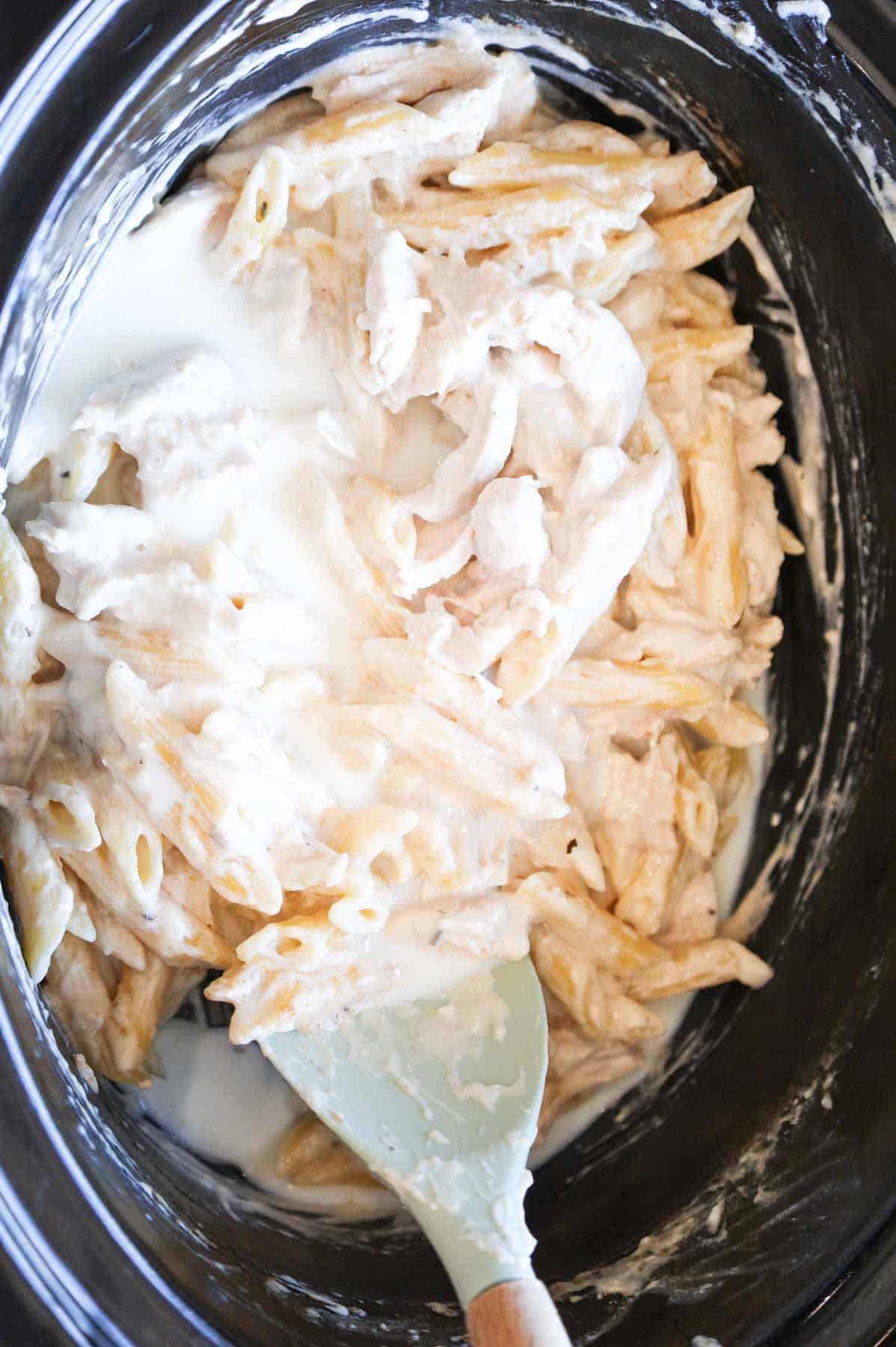 milk added to crock pot with creamy chicken pasta